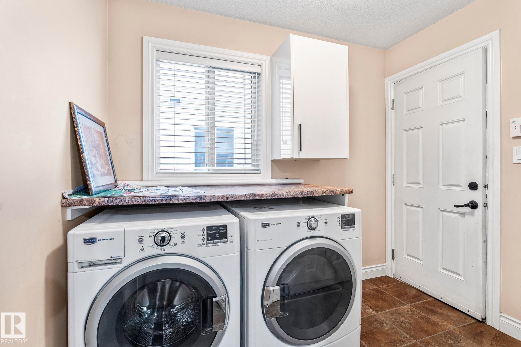 Laundry area featuring washing machine and clothes dryer and cabinet space - 1888 33 Street, Edmonton, AB - Indoor Photo Showing Laundry Room