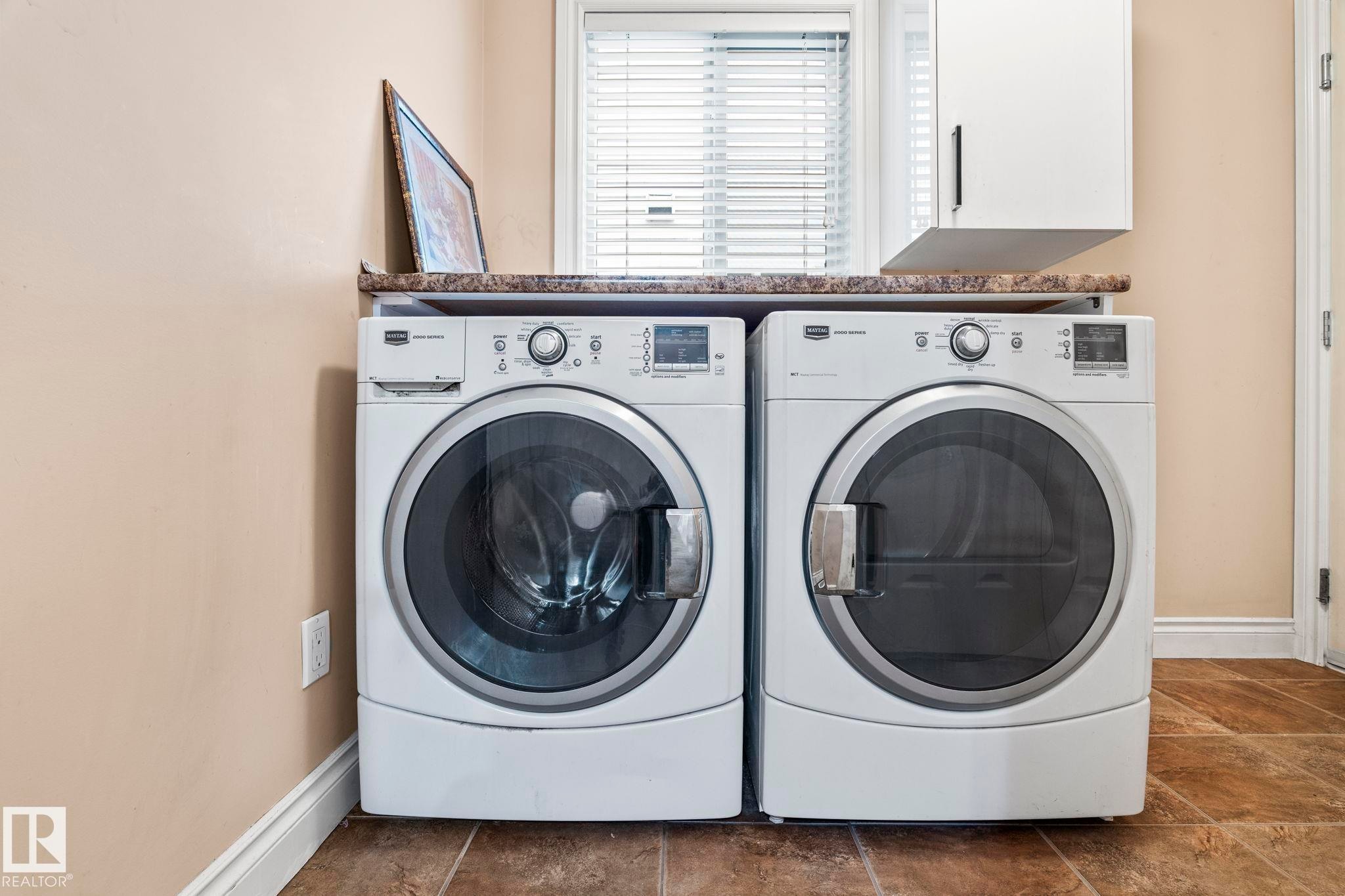Laundry area featuring washing machine and dryer and cabinet space - 1888 33 Street, Edmonton, AB - Indoor Photo Showing Laundry Room