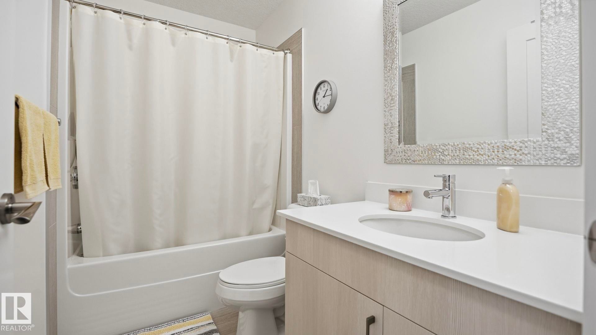 Full bath featuring vanity and shower / tub combo with curtain - 401 17 Columbia Avenue W, Devon, AB - Indoor Photo Showing Bathroom