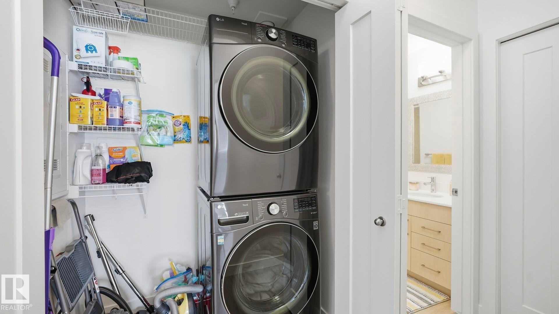 Laundry room with stacked washer and clothes dryer and a sink - 401 17 Columbia Avenue W, Devon, AB - Indoor Photo Showing Laundry Room