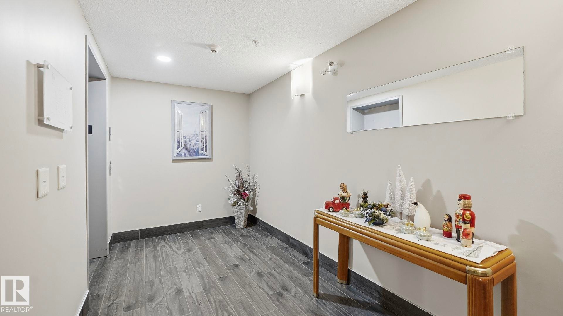 Hall with wood tiled floors and a textured ceiling - 401 17 Columbia Avenue W, Devon, AB - Indoor Photo Showing Other Room