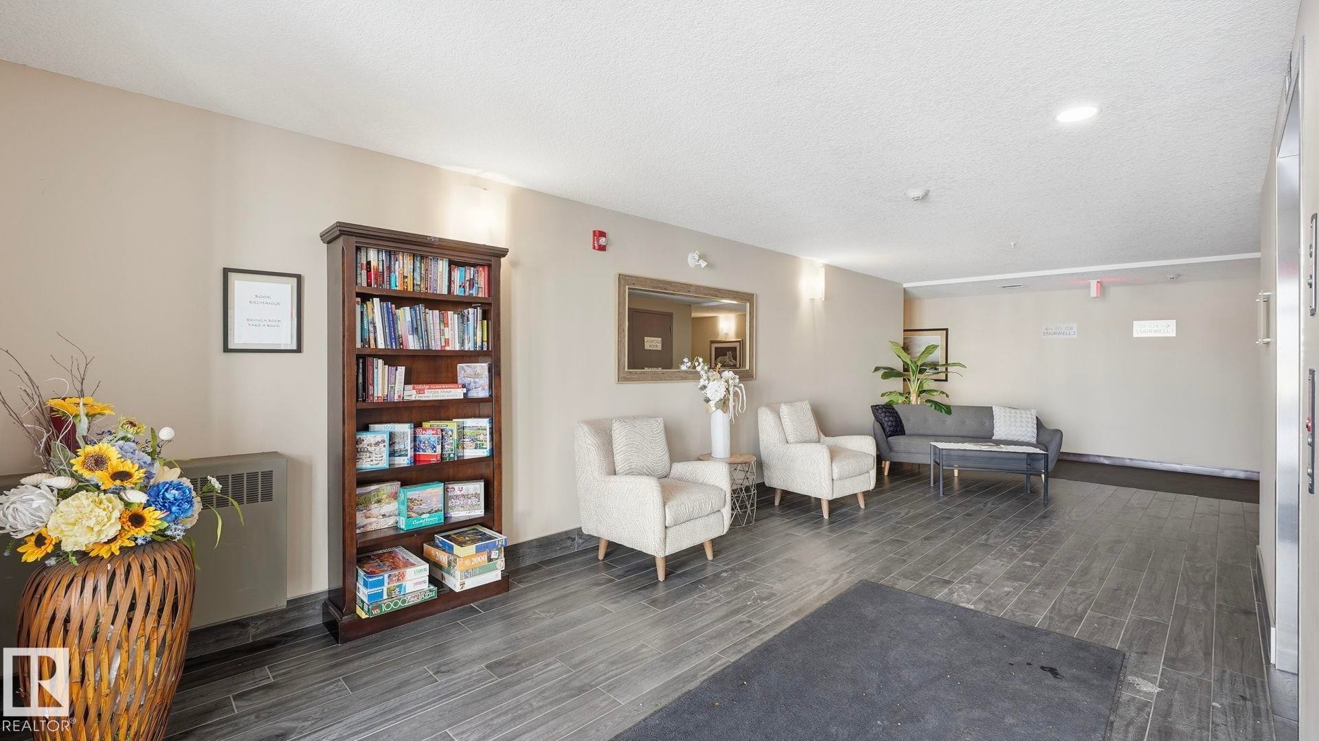 Living area featuring radiator and a textured ceiling - 401 17 Columbia Avenue W, Devon, AB - Indoor