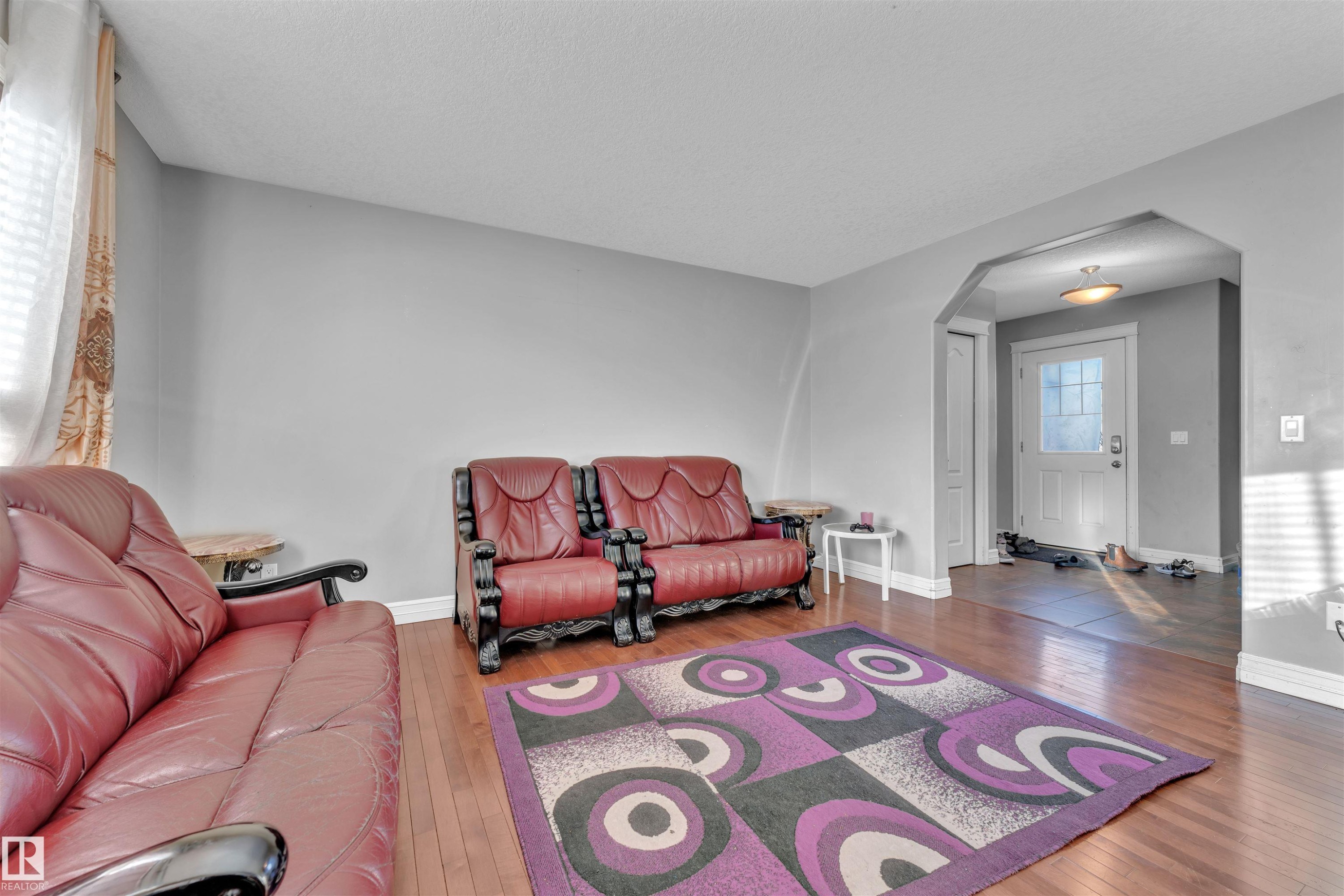 Living room featuring arched walkways and hardwood / wood-style flooring - 3015 26 Ave Nw, Edmonton, AB - Indoor