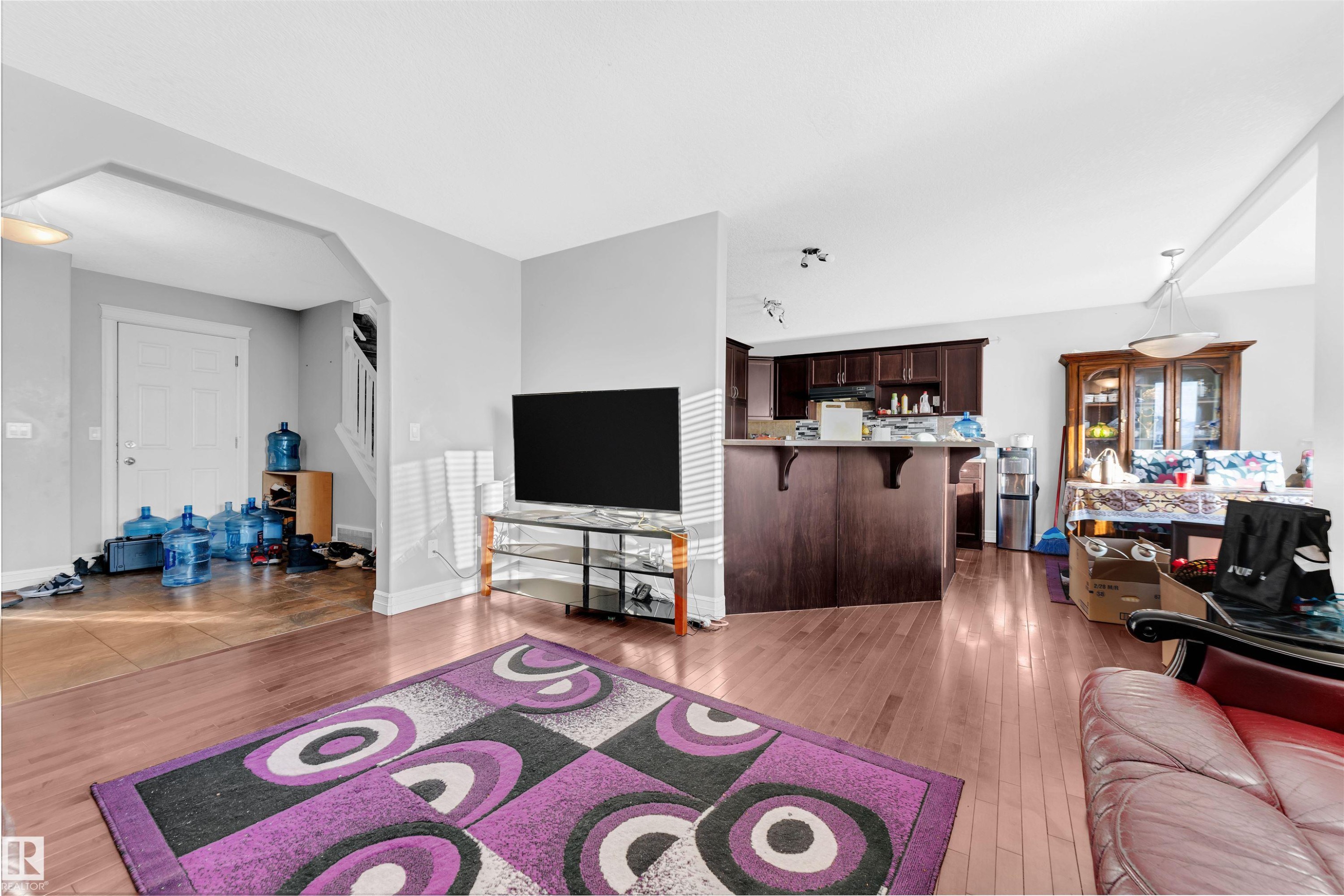 Living room featuring dark wood-style flooring and arched walkways - 3015 26 Ave Nw, Edmonton, AB - Indoor Photo Showing Living Room