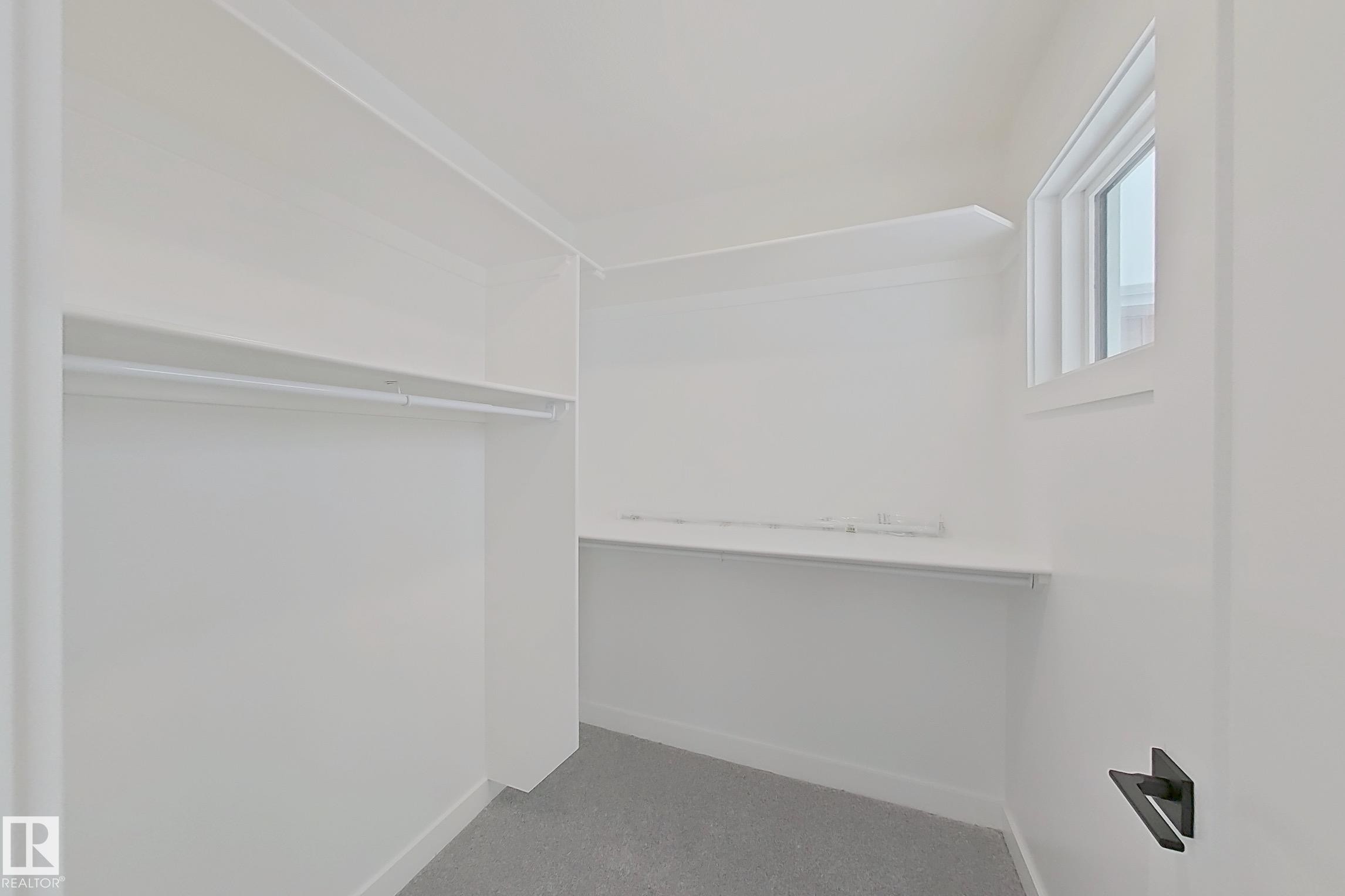 Walk in closet with dark colored carpet - 3158 Magpie Way, Edmonton, AB - Indoor With Storage