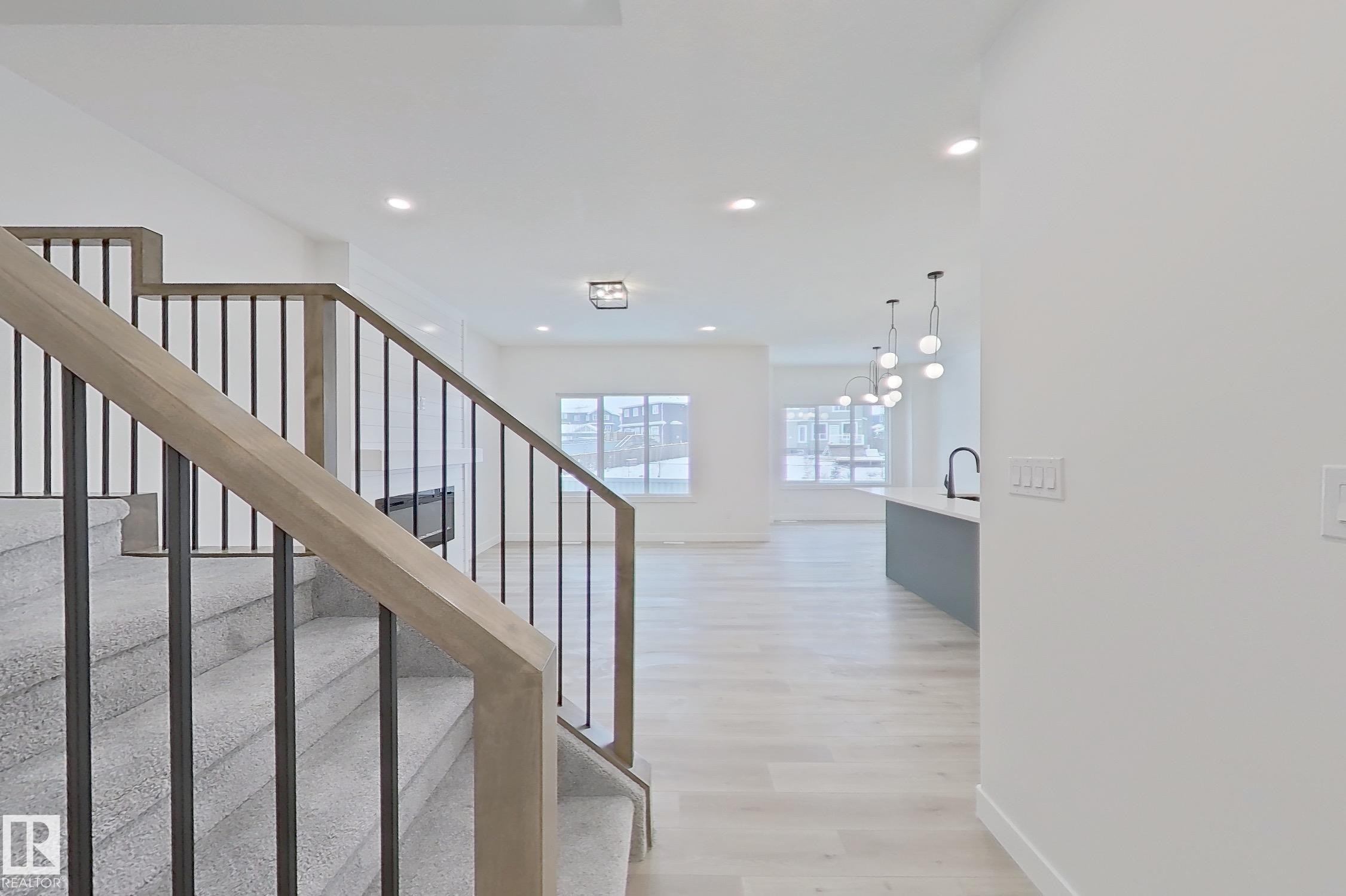 Stairway featuring wood finished floors, recessed lighting, and a chandelier - 3158 Magpie Way, Edmonton, AB - Indoor Photo Showing Other Room