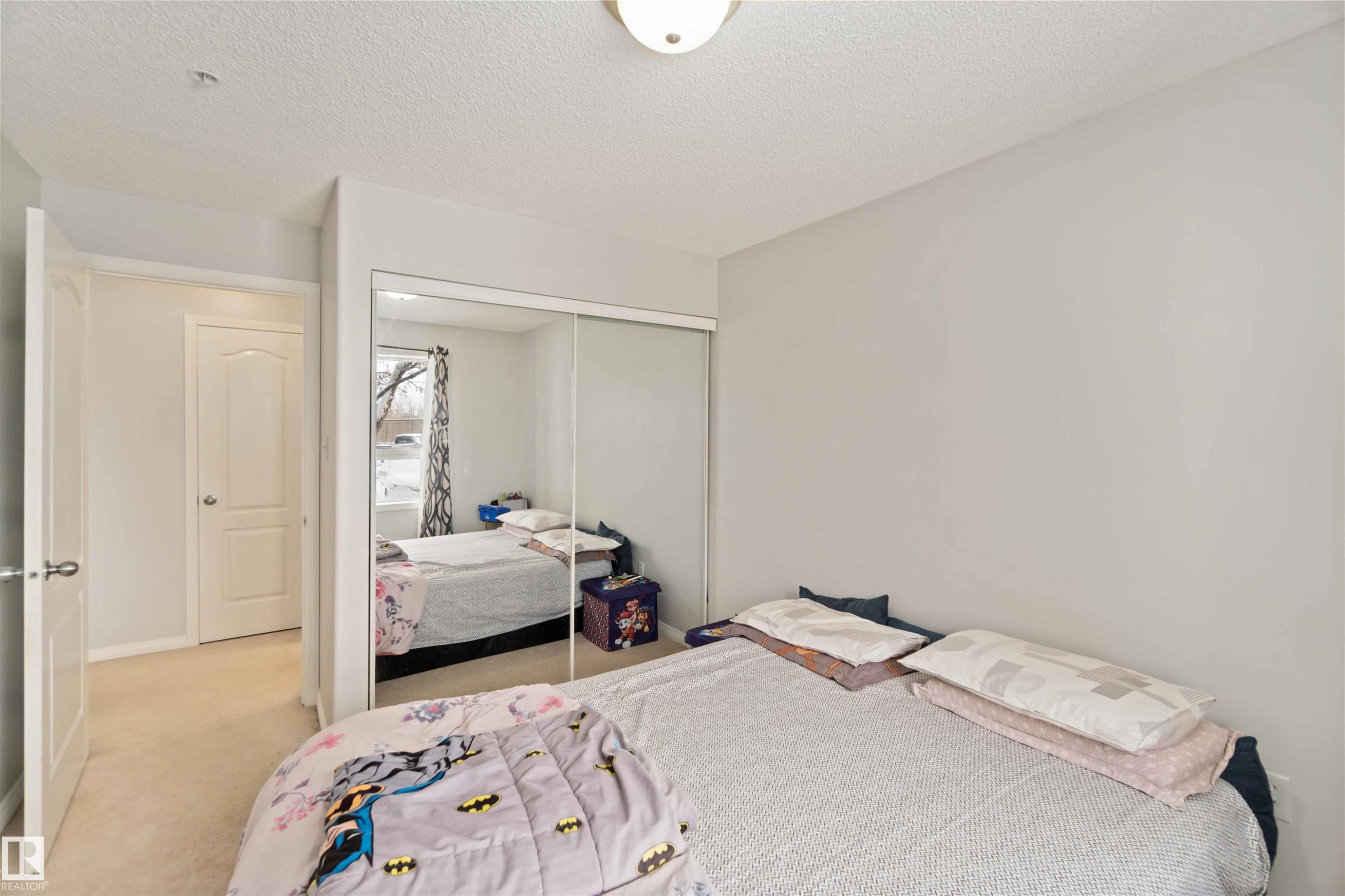Carpeted bedroom featuring a textured ceiling and a closet - 2117 9357 Simpson Drive, Edmonton, AB - Indoor Photo Showing Bedroom