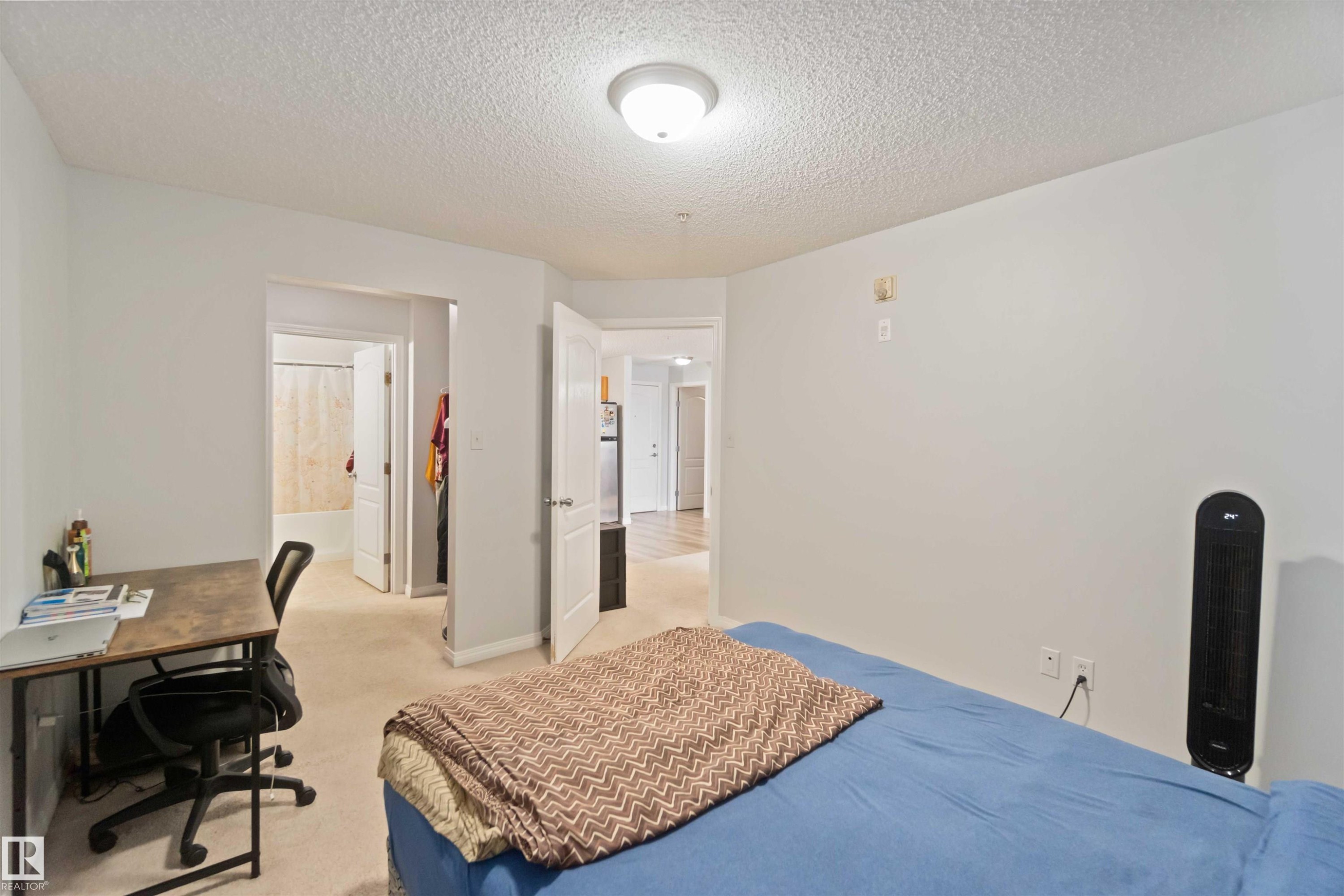 Bedroom featuring a textured ceiling, an office area, and light carpet - 2117 9357 Simpson Drive, Edmonton, AB - Indoor