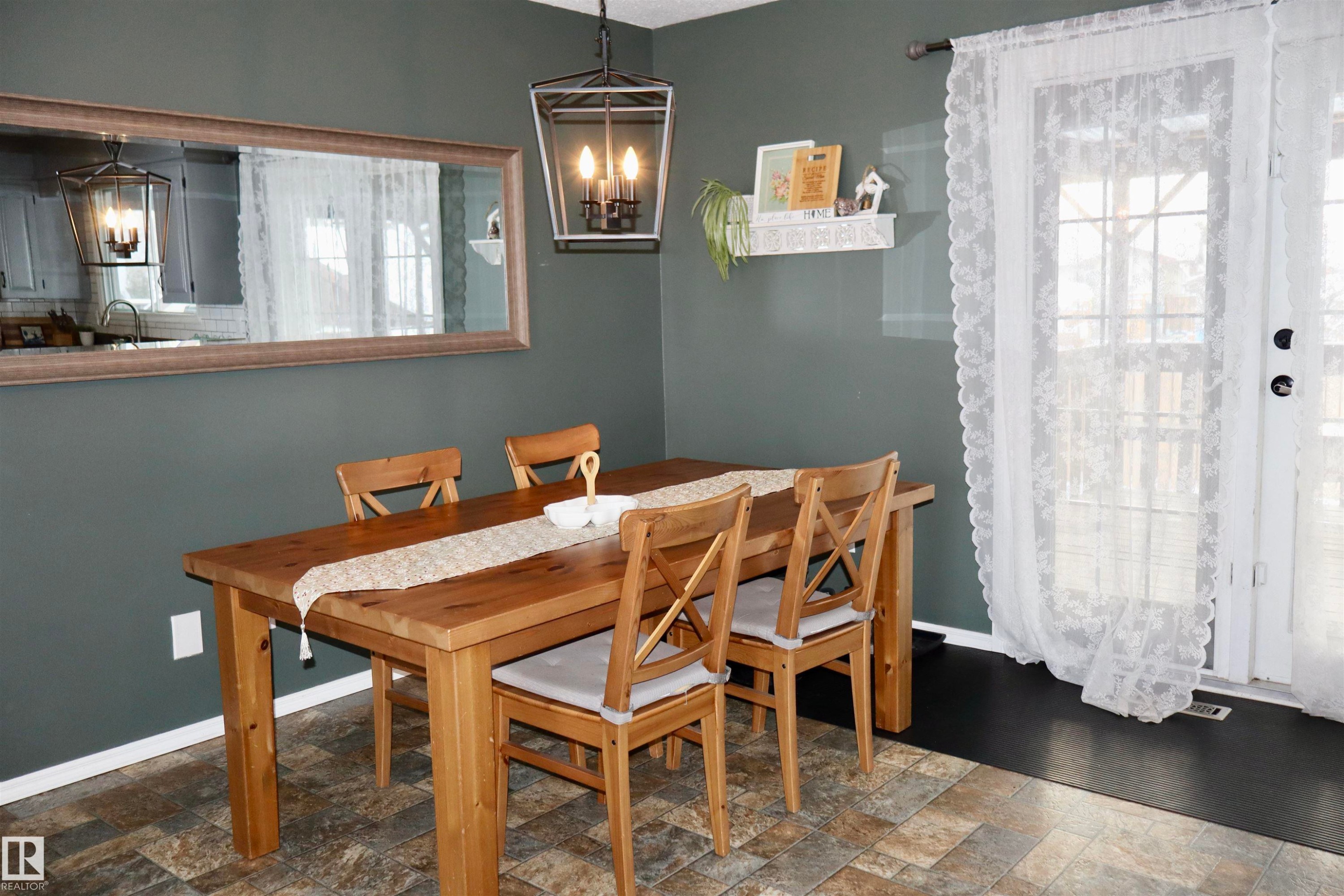 Dining room featuring a chandelier, stone finish flooring, and plenty of natural light - 4505 58 Avenue, Barrhead, AB - Indoor Photo Showing Dining Room