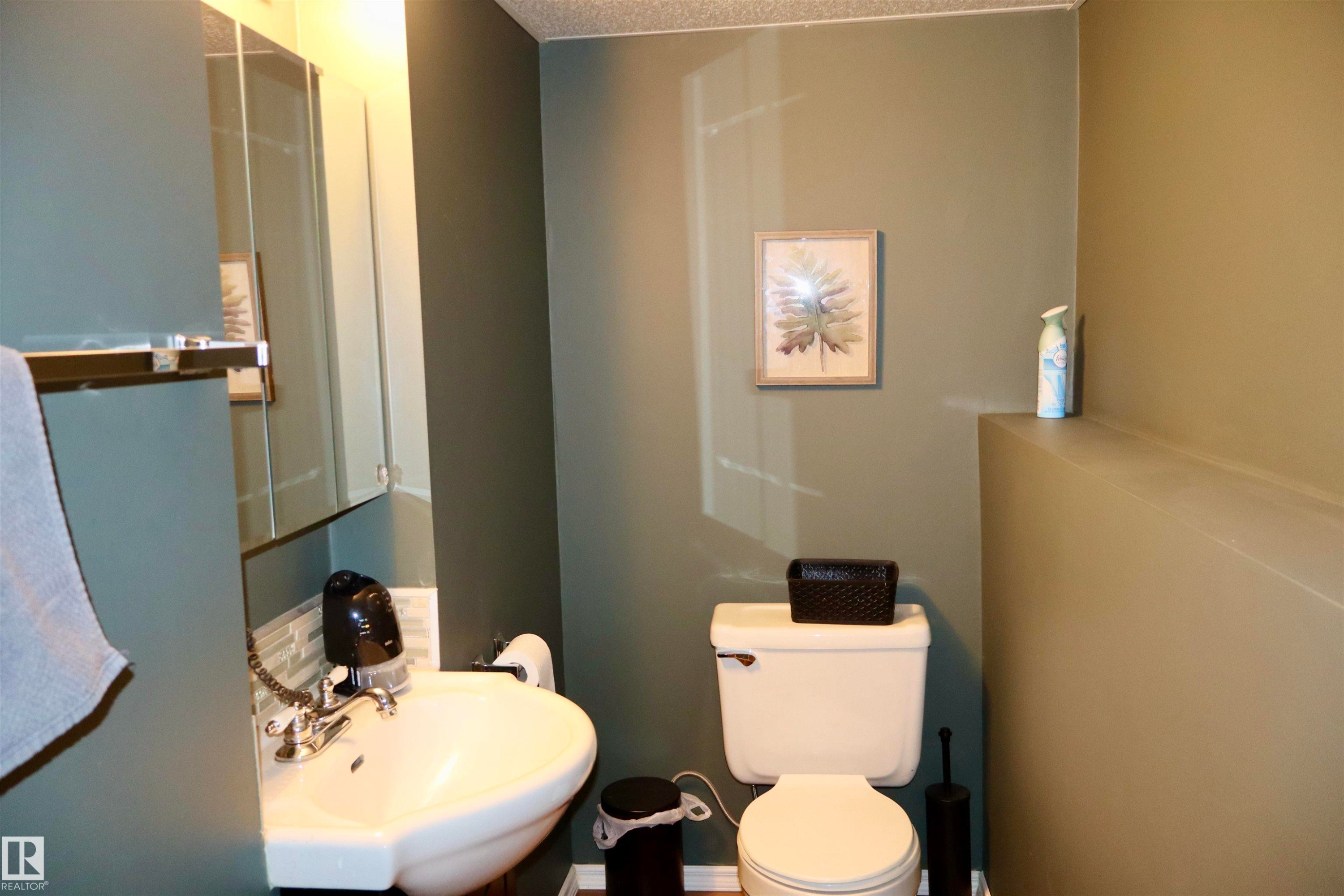 Half bath featuring toilet and a textured ceiling - 4505 58 Avenue, Barrhead, AB - Indoor Photo Showing Bathroom