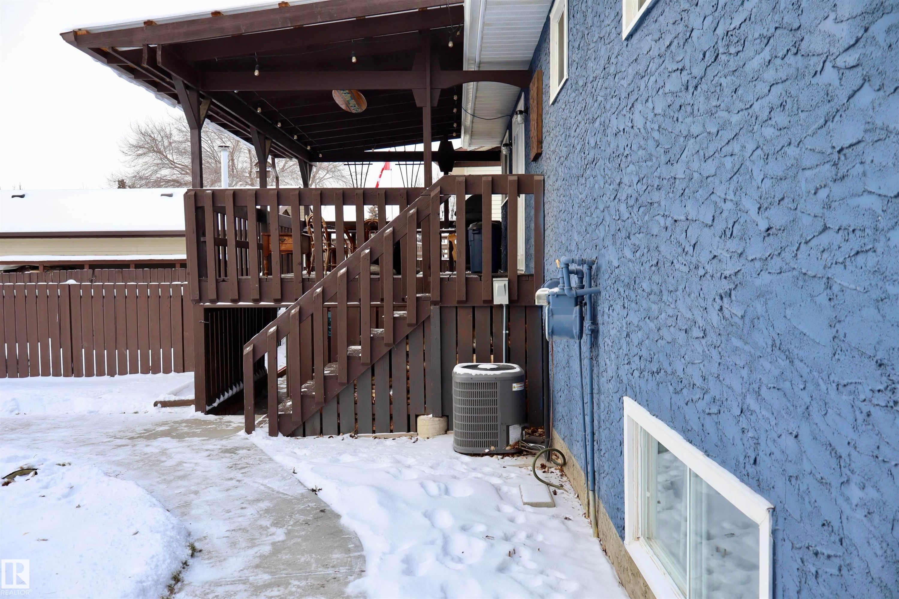 Snow covered patio with stairs and a wooden deck - 4505 58 Avenue, Barrhead, AB - Outdoor