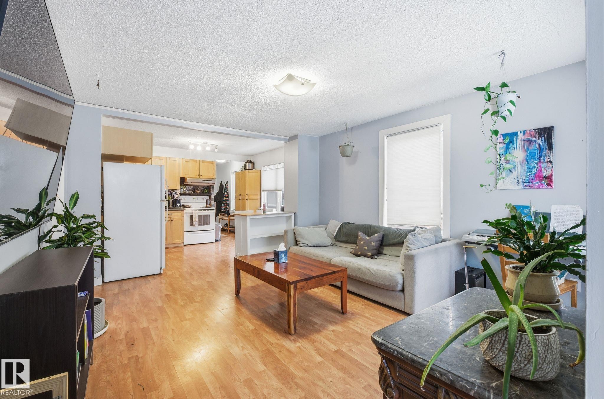 Living room with a textured ceiling and light wood finished floors - 9705 87 Avenue, Edmonton, AB - Indoor Photo Showing Living Room