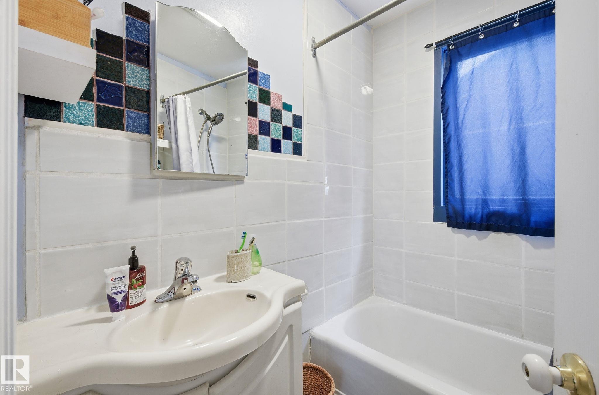 Full bathroom with tile walls, vanity, and shower / bathtub combination with curtain - 9705 87 Avenue, Edmonton, AB - Indoor Photo Showing Bathroom