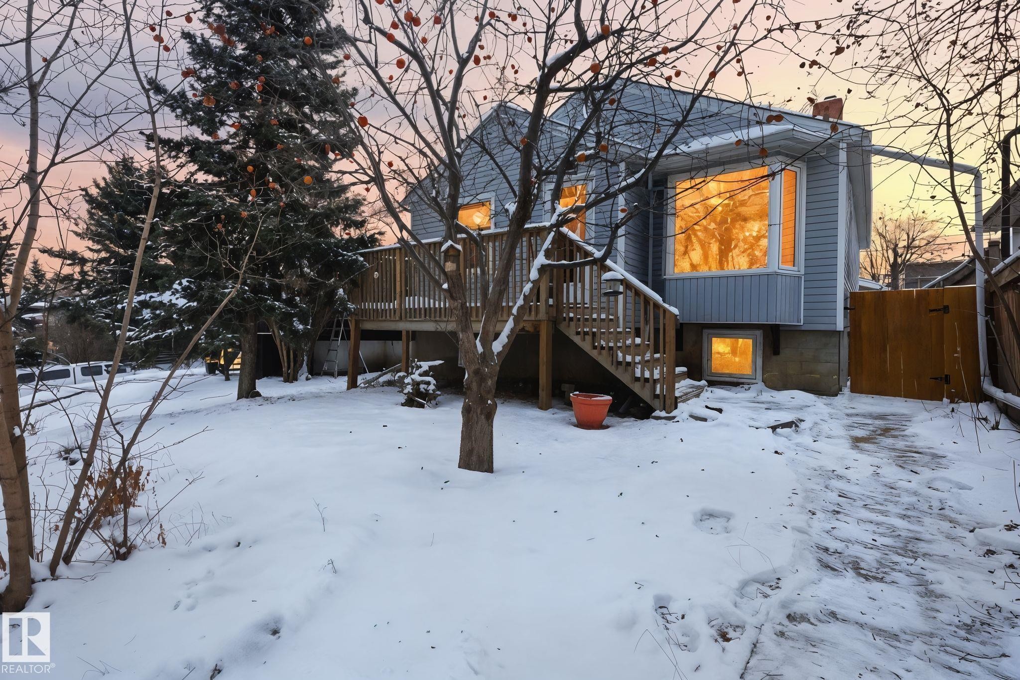 Snow covered house featuring stairs, a wooden deck, and a chimney - 9705 87 Avenue, Edmonton, AB - Outdoor
