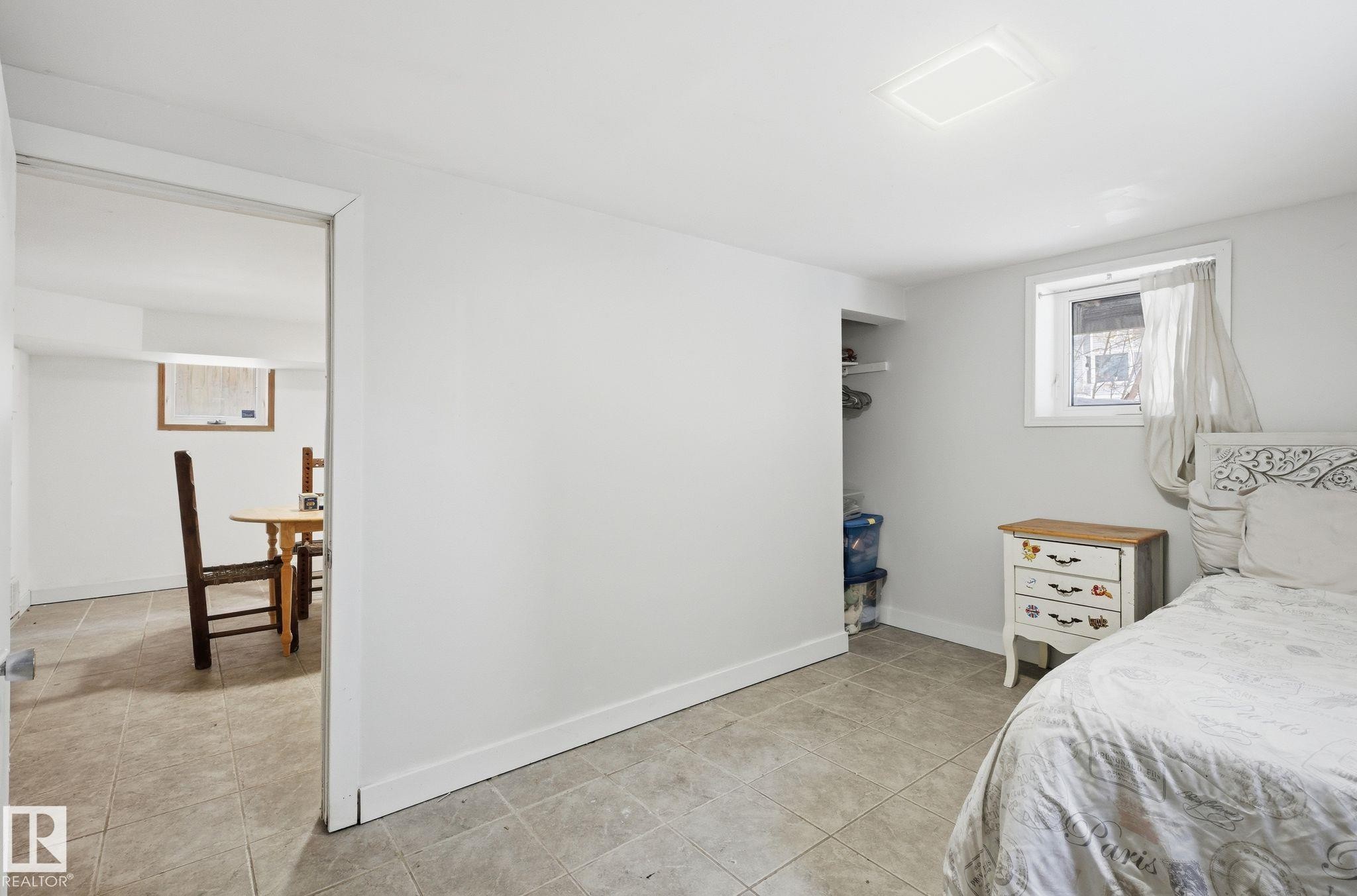 Bedroom with a closet and light tile patterned floors - 9705 87 Avenue, Edmonton, AB - Indoor Photo Showing Bedroom