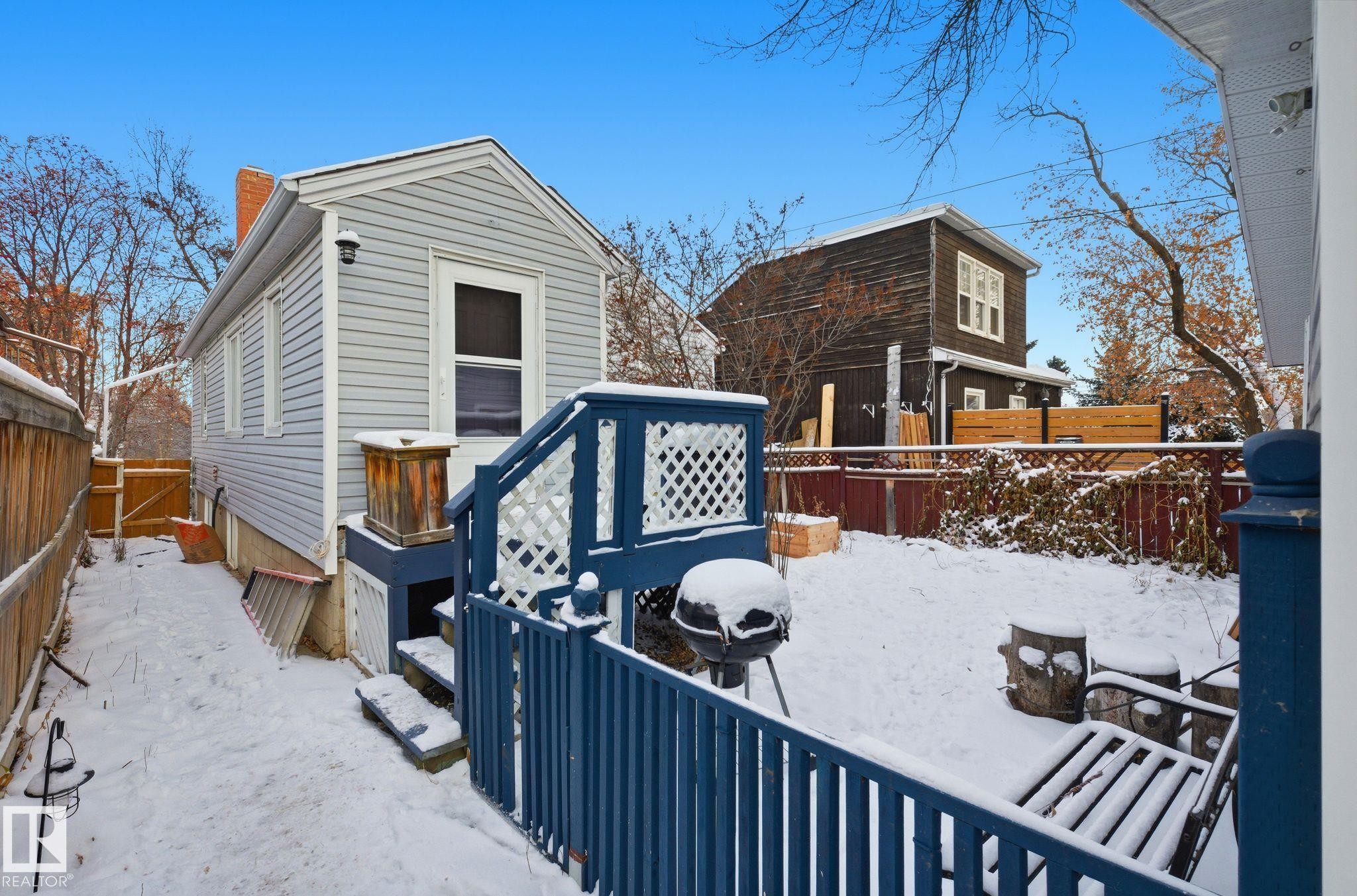 Snow covered patio with a fenced backyard and a deck - 9705 87 Avenue, Edmonton, AB - Outdoor With Deck Patio Veranda With Exterior