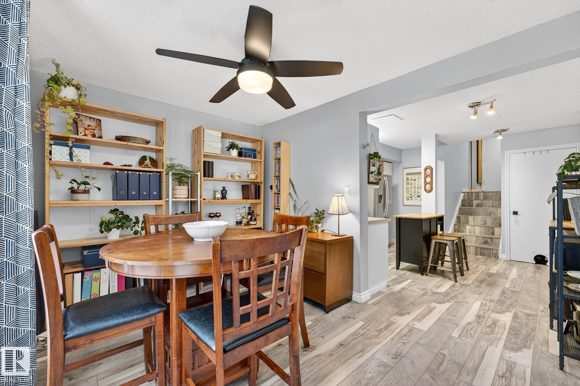 Dining space with light wood-type flooring, stairs, and a ceiling fan - 7 Grandview Ridge, St. Albert, AB - Indoor Photo Showing Dining Room