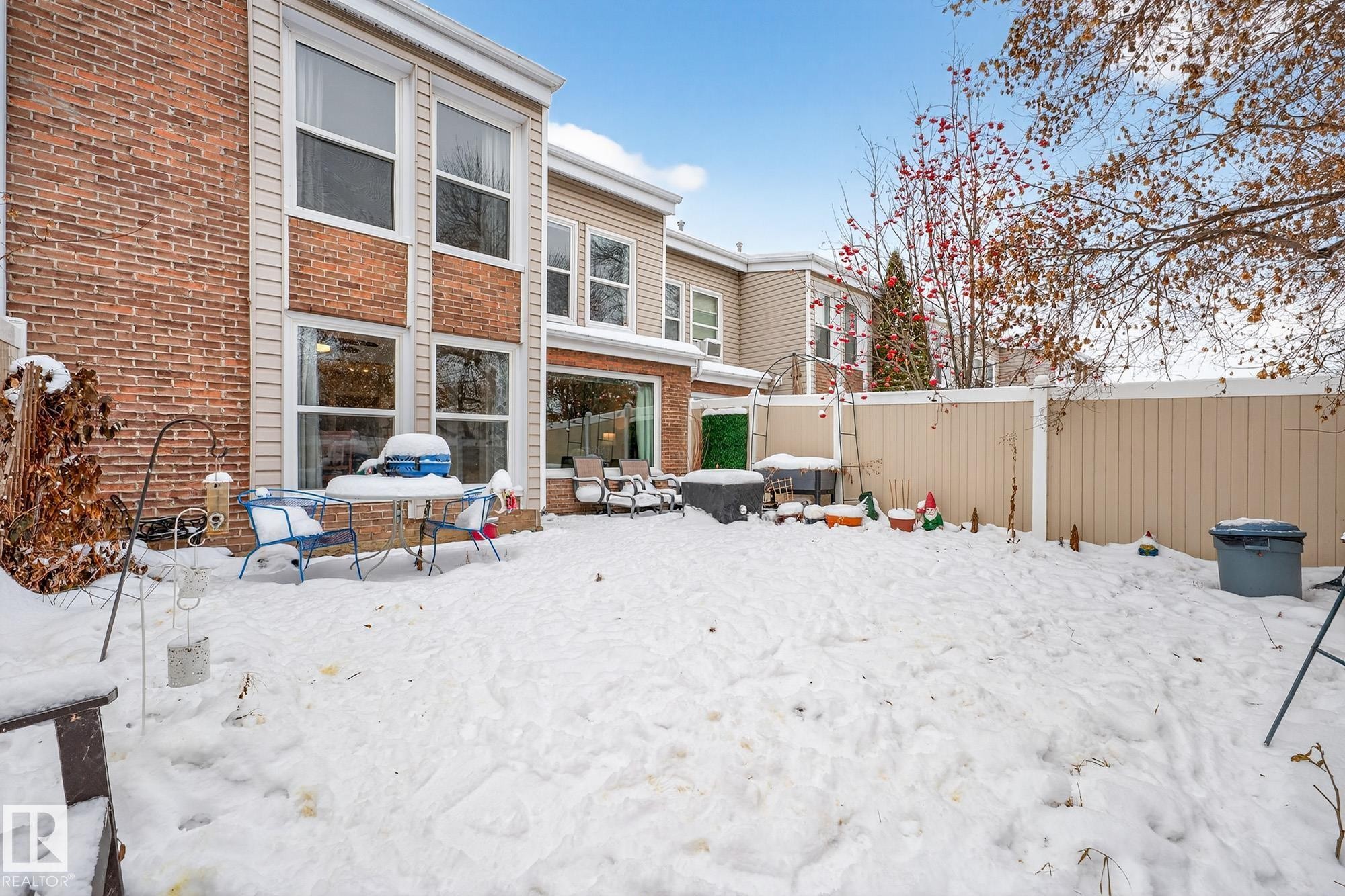 Snow covered house with brick siding, a fenced backyard, and a patio area - 7 Grandview Ridge, St. Albert, AB - Outdoor