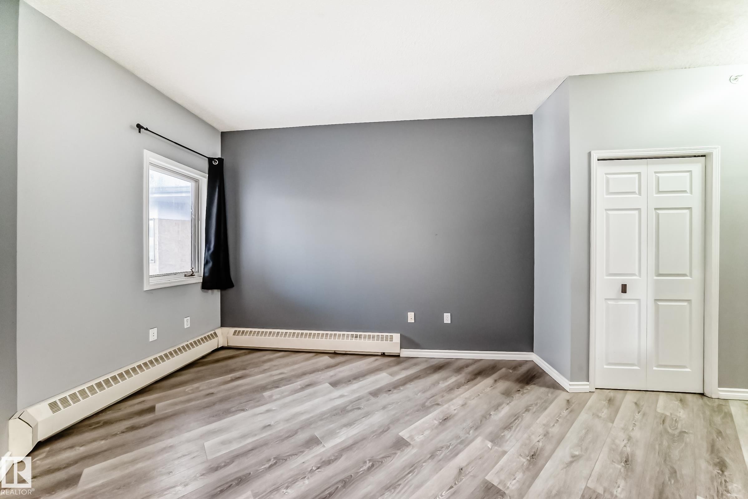 Empty room with a baseboard heating unit and light wood-style flooring - 507 11716 100 Avenue, Edmonton, AB - Indoor Photo Showing Other Room