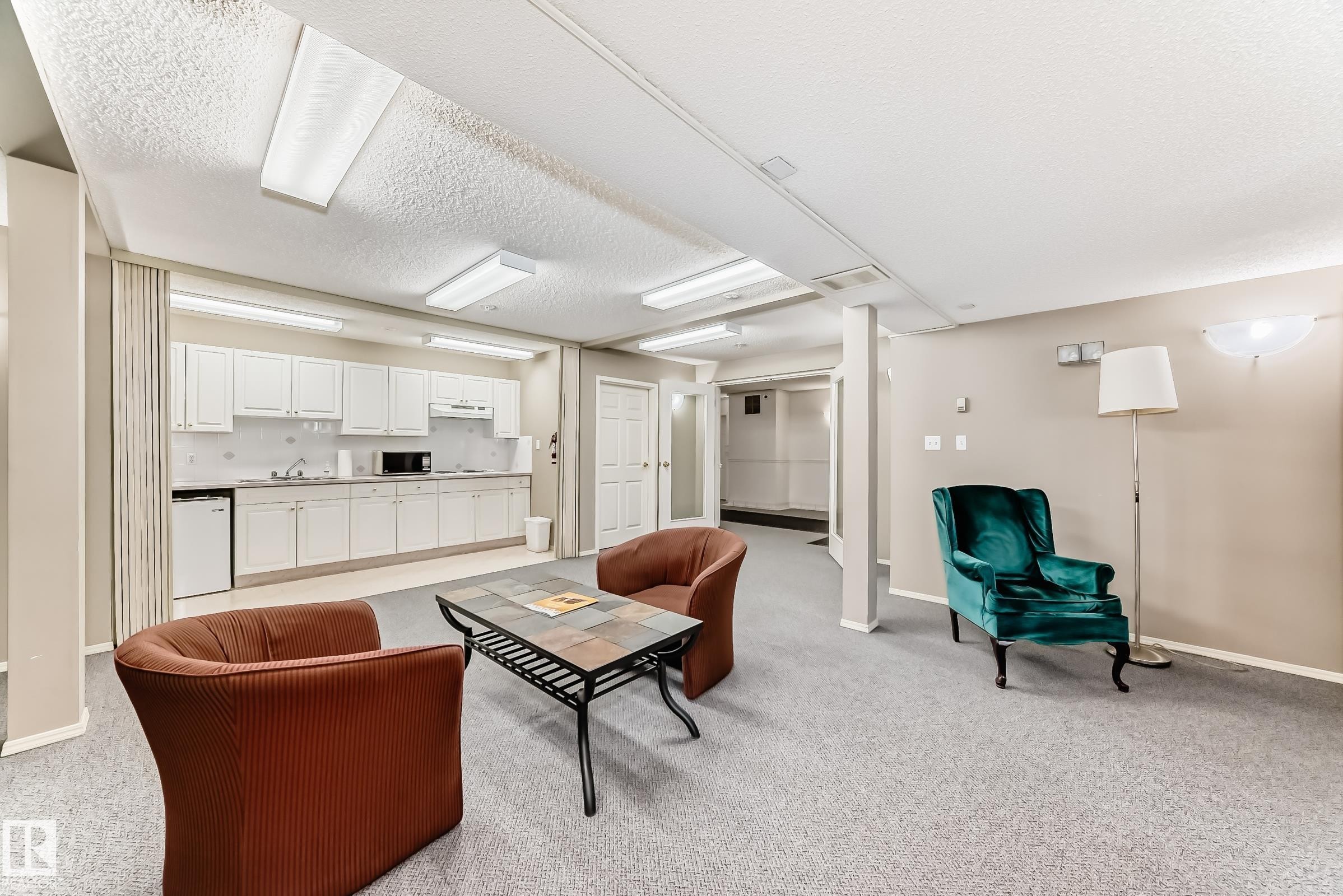 Living area featuring light colored carpet and a textured ceiling - 507 11716 100 Avenue, Edmonton, AB - Indoor