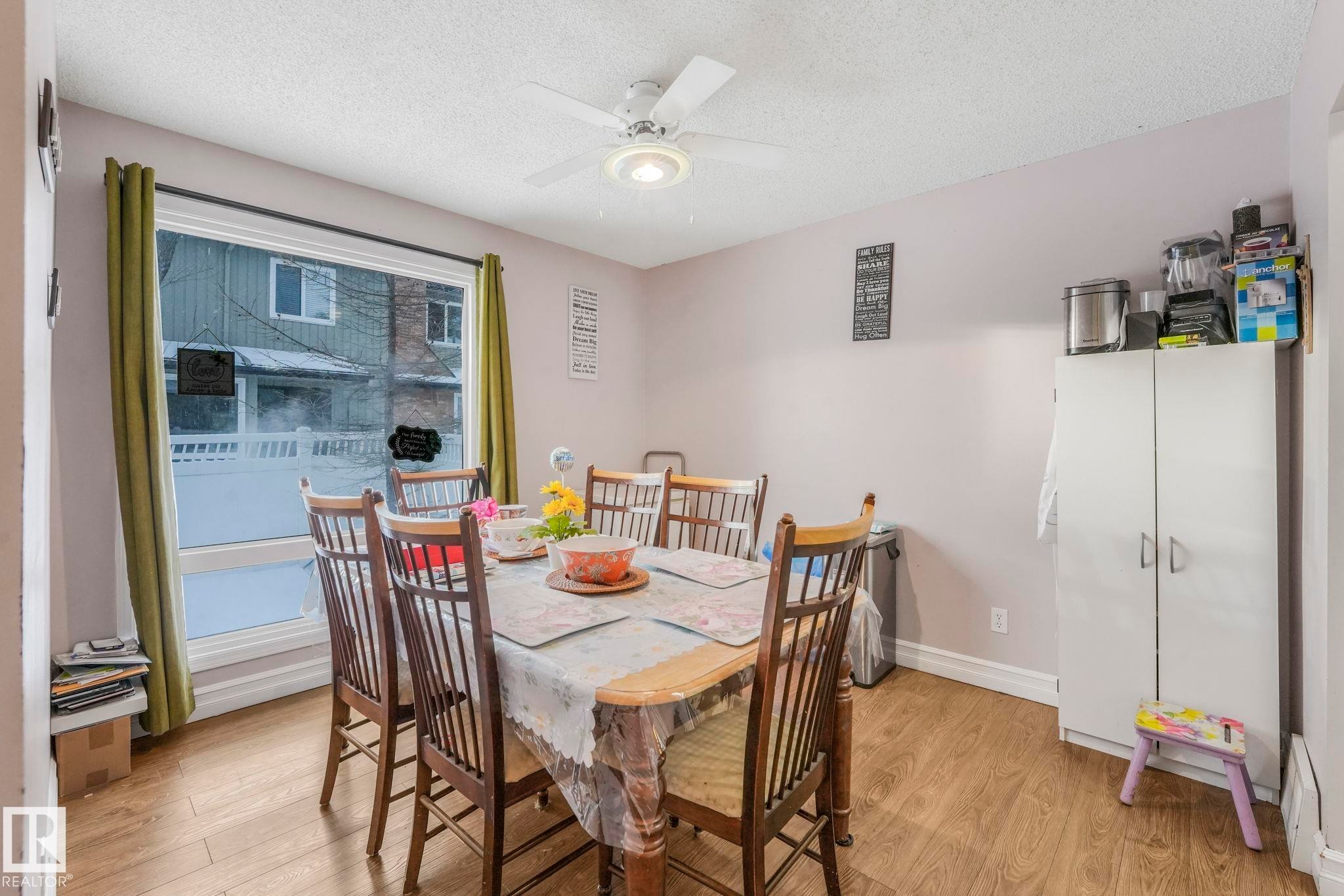 Dining room featuring light wood finished floors, a textured ceiling, and ceiling fan - 11811 32A Avenue, Edmonton, AB - Indoor Photo Showing Dining Room