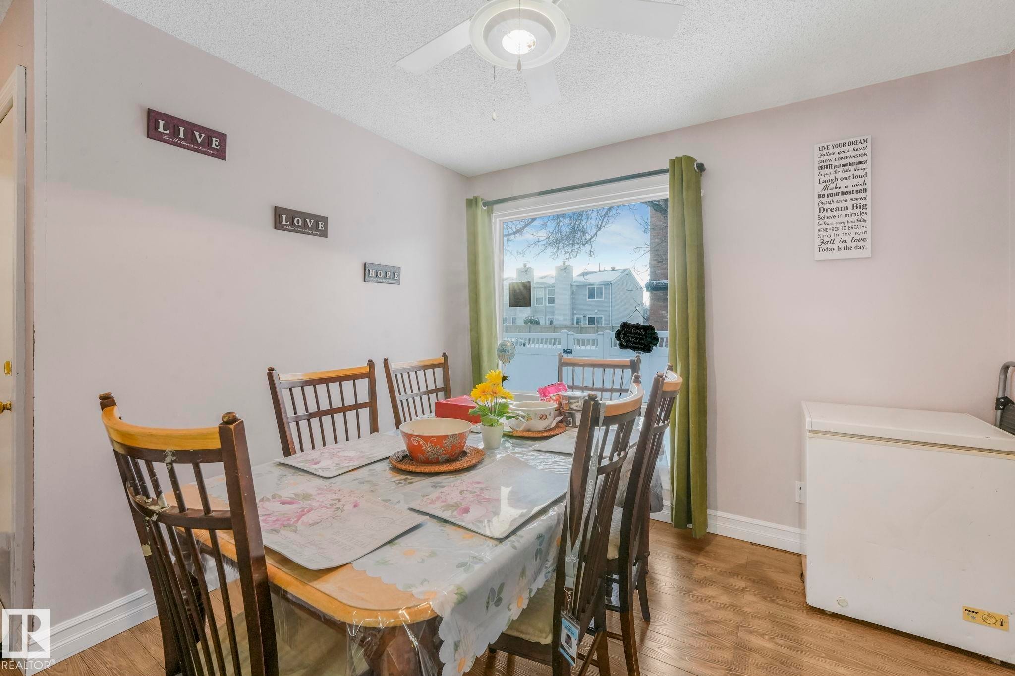Dining room featuring a textured ceiling, light wood finished floors, and a ceiling fan - 11811 32A Avenue, Edmonton, AB - Indoor Photo Showing Dining Room