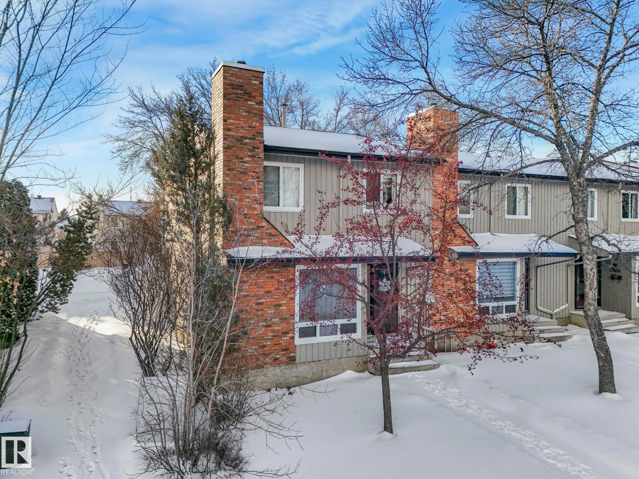 View of front of house featuring a chimney, board and batten siding, and brick siding - 11811 32A Avenue, Edmonton, AB - Outdoor