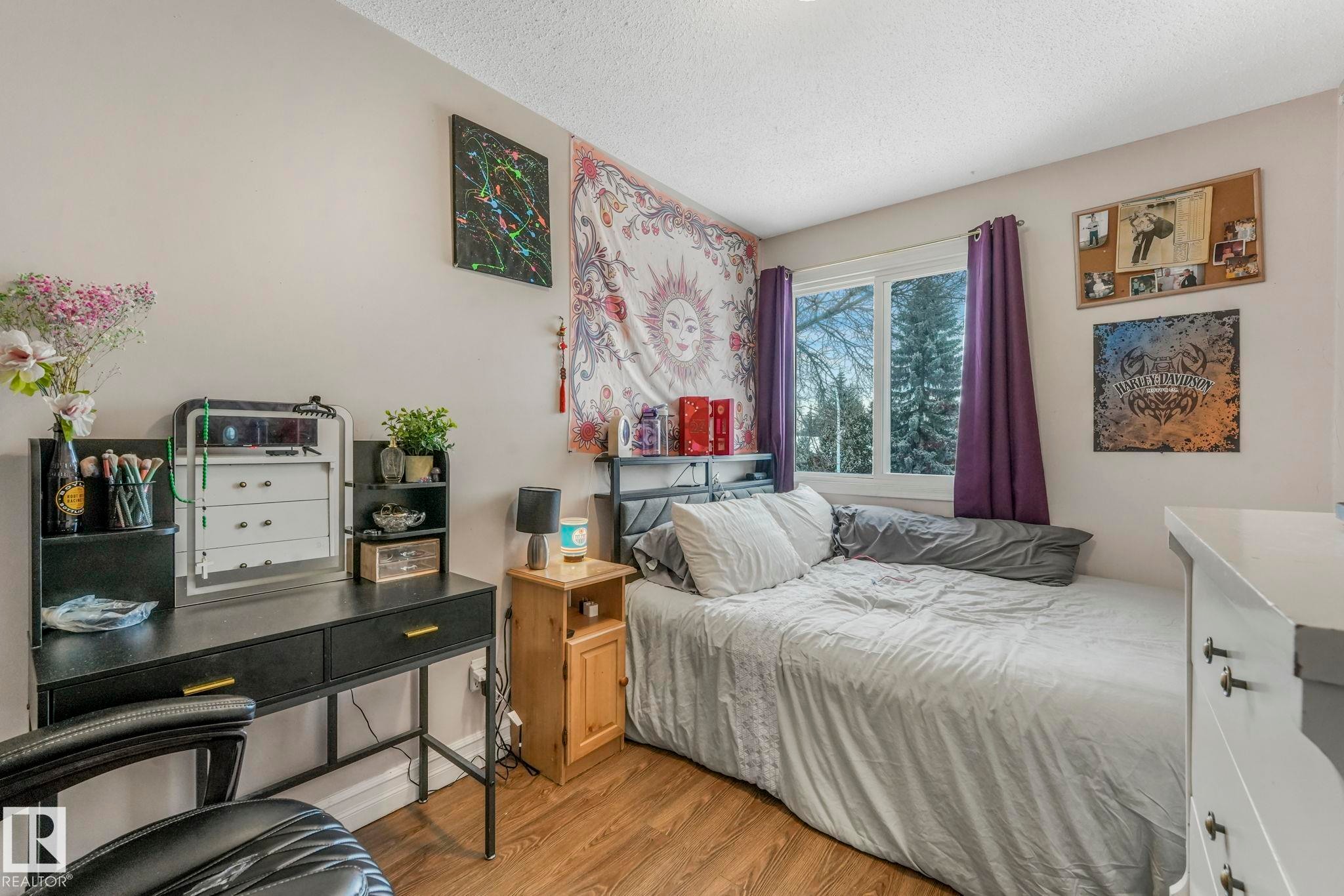 Bedroom with a textured ceiling and light wood-style floors - 11811 32A Avenue, Edmonton, AB - Indoor Photo Showing Bedroom