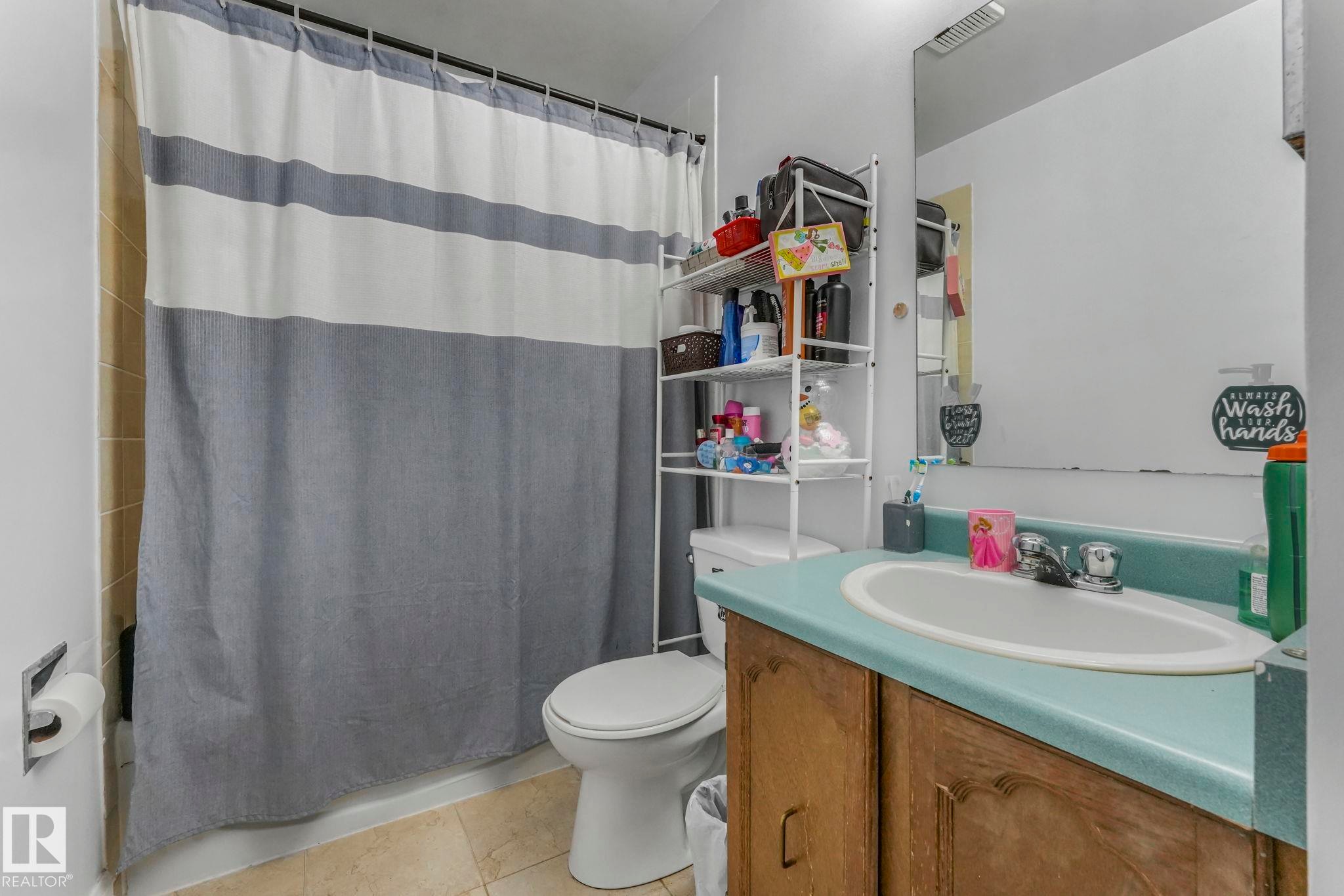 Full bath with vanity, light tile patterned floors, and shower / bathtub combination with curtain - 11811 32A Avenue, Edmonton, AB - Indoor Photo Showing Bathroom