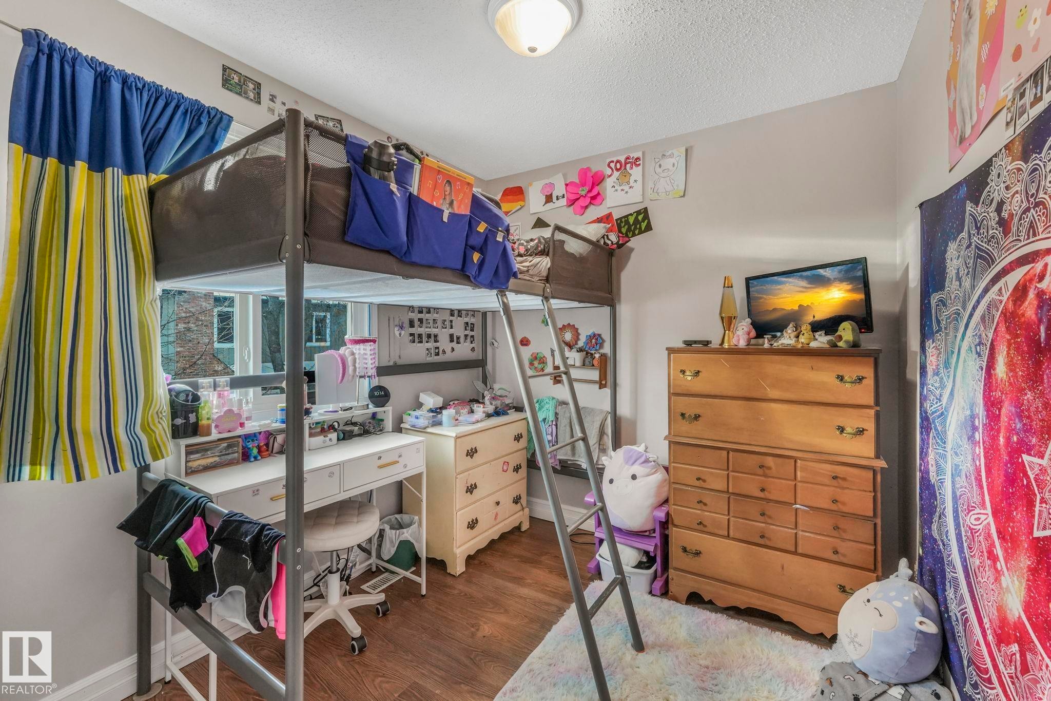 Bedroom with wood finished floors and a textured ceiling - 11811 32A Avenue, Edmonton, AB - Indoor