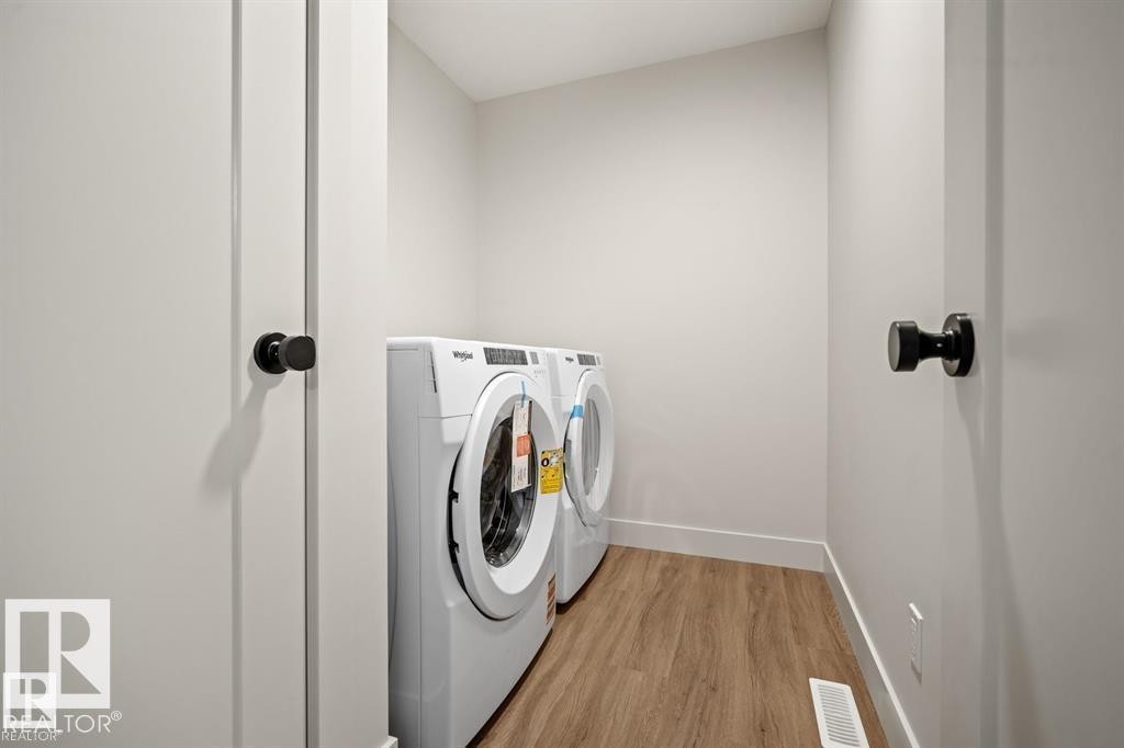 Laundry room with separate washer and dryer and wood finished floors - 24 Grayson Green, Stony Plain, AB - Indoor Photo Showing Laundry Room