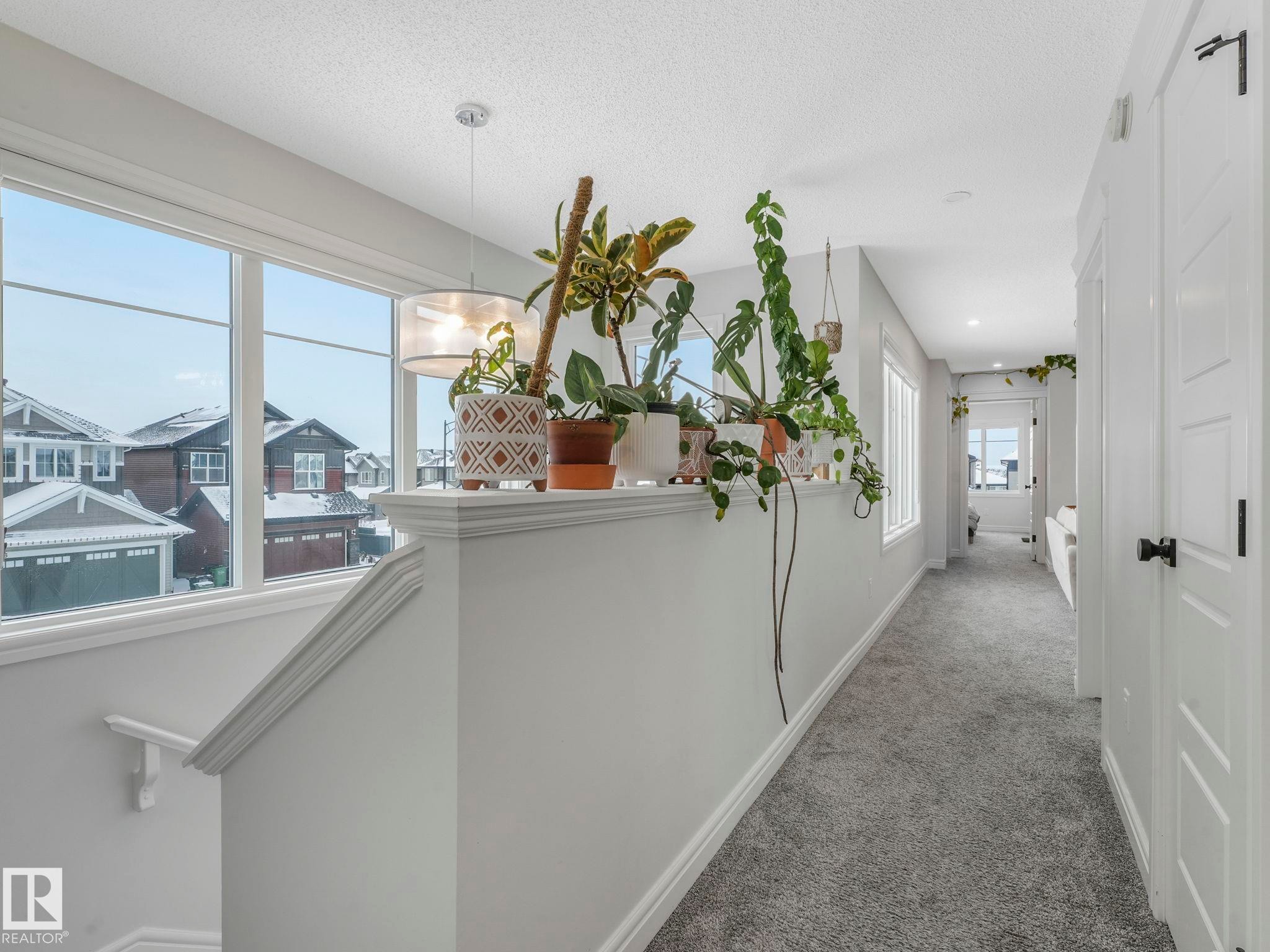 Hallway with carpet flooring, a textured ceiling, and an upstairs landing - 4447 Kinsella Green, Edmonton, AB - Indoor Photo Showing Other Room