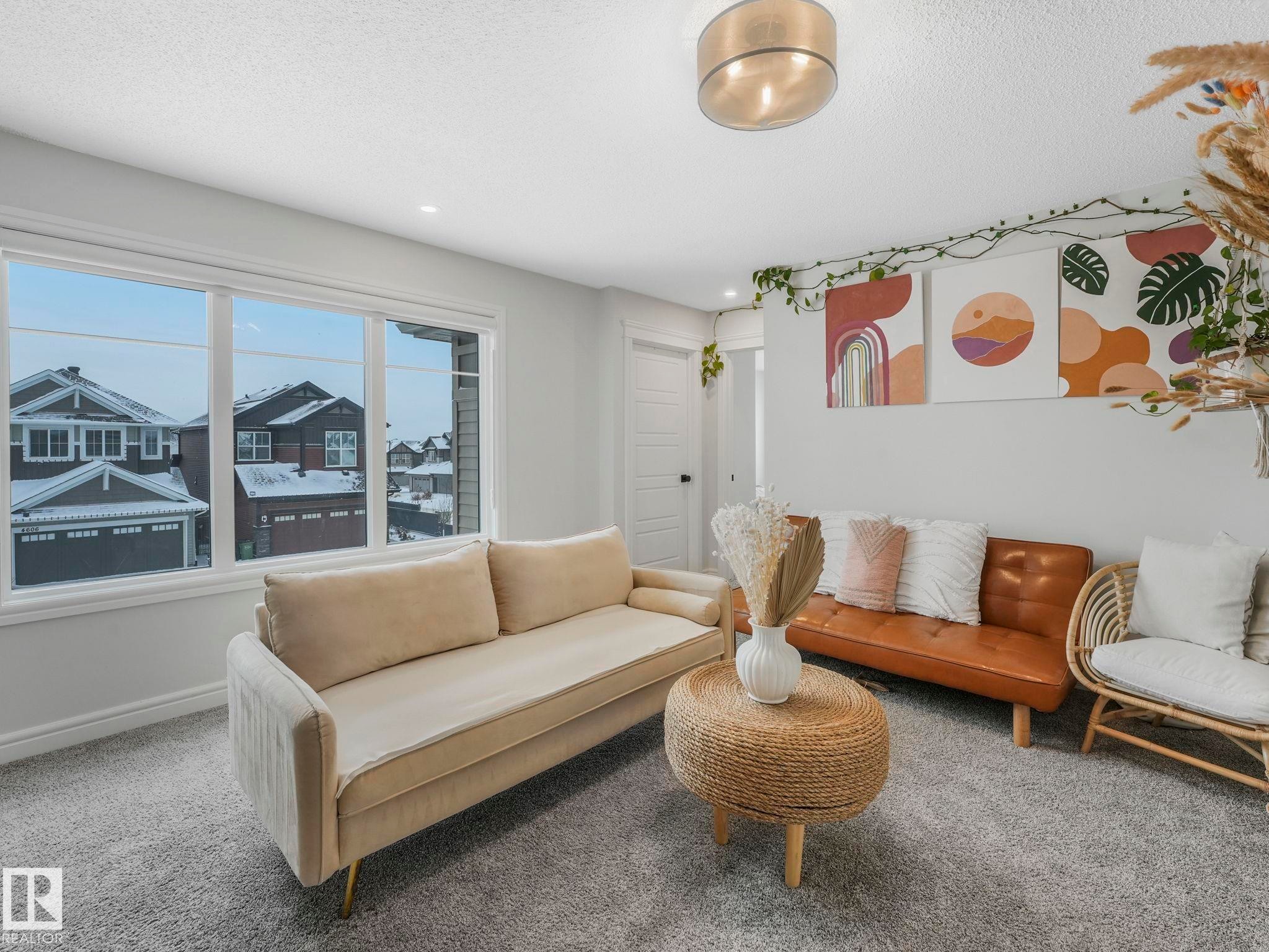 Living area featuring carpet flooring and a textured ceiling - 4447 Kinsella Green, Edmonton, AB - Indoor Photo Showing Living Room