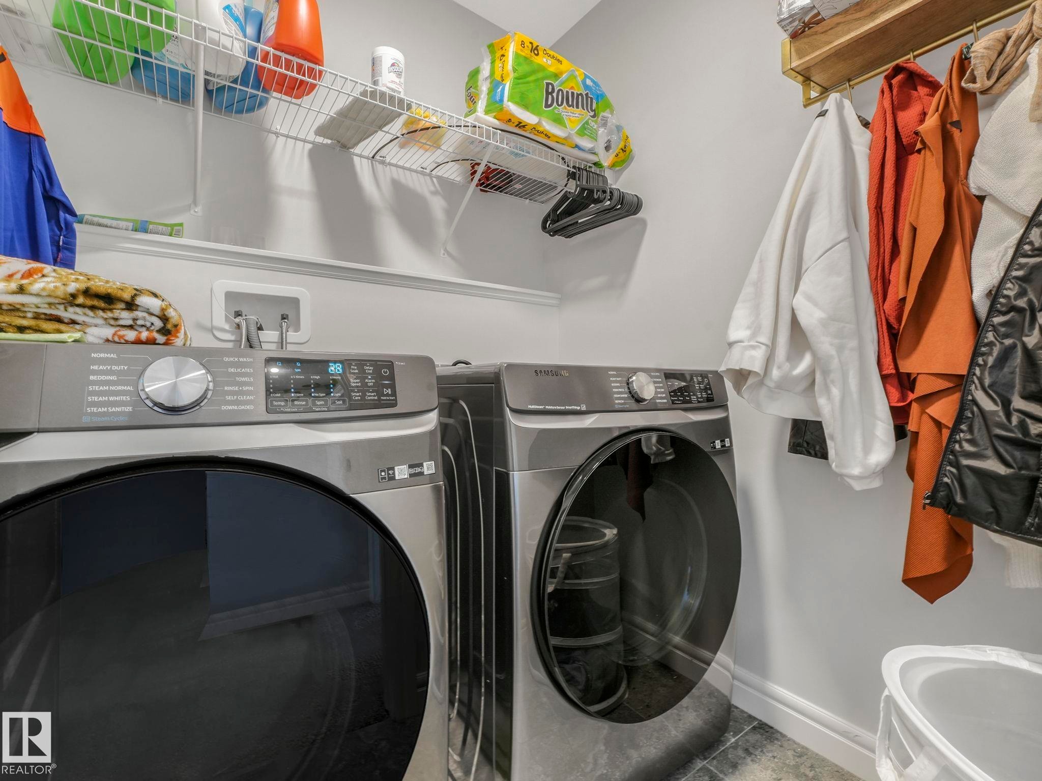 Laundry area featuring baseboards and washing machine and clothes dryer - 4447 Kinsella Green, Edmonton, AB - Indoor Photo Showing Laundry Room