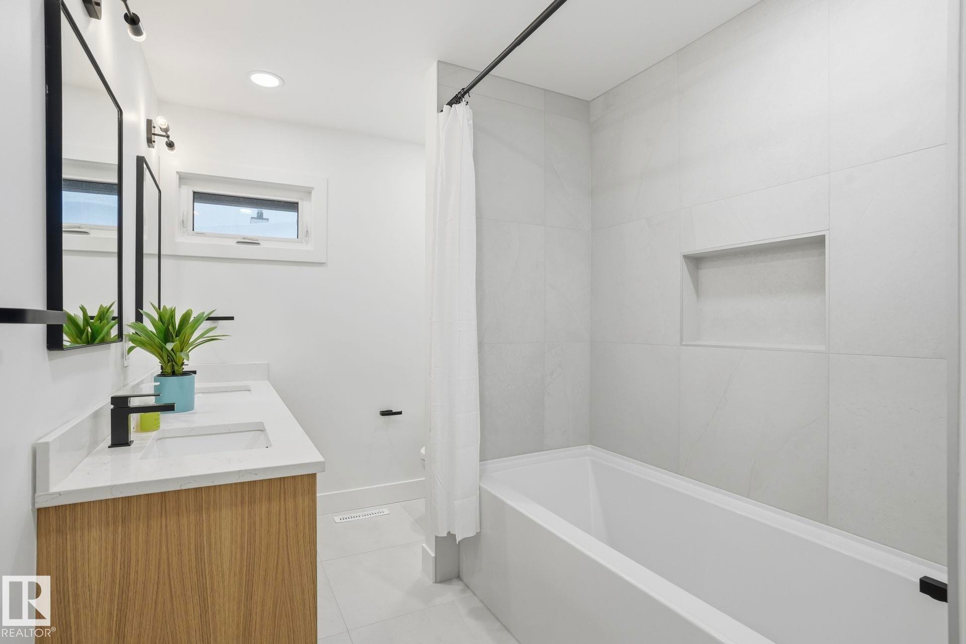 Full bath featuring double vanity, shower / tub combo, light tile patterned floors, and recessed lighting - 14604 Mackenzie Drive, Edmonton, AB - Indoor