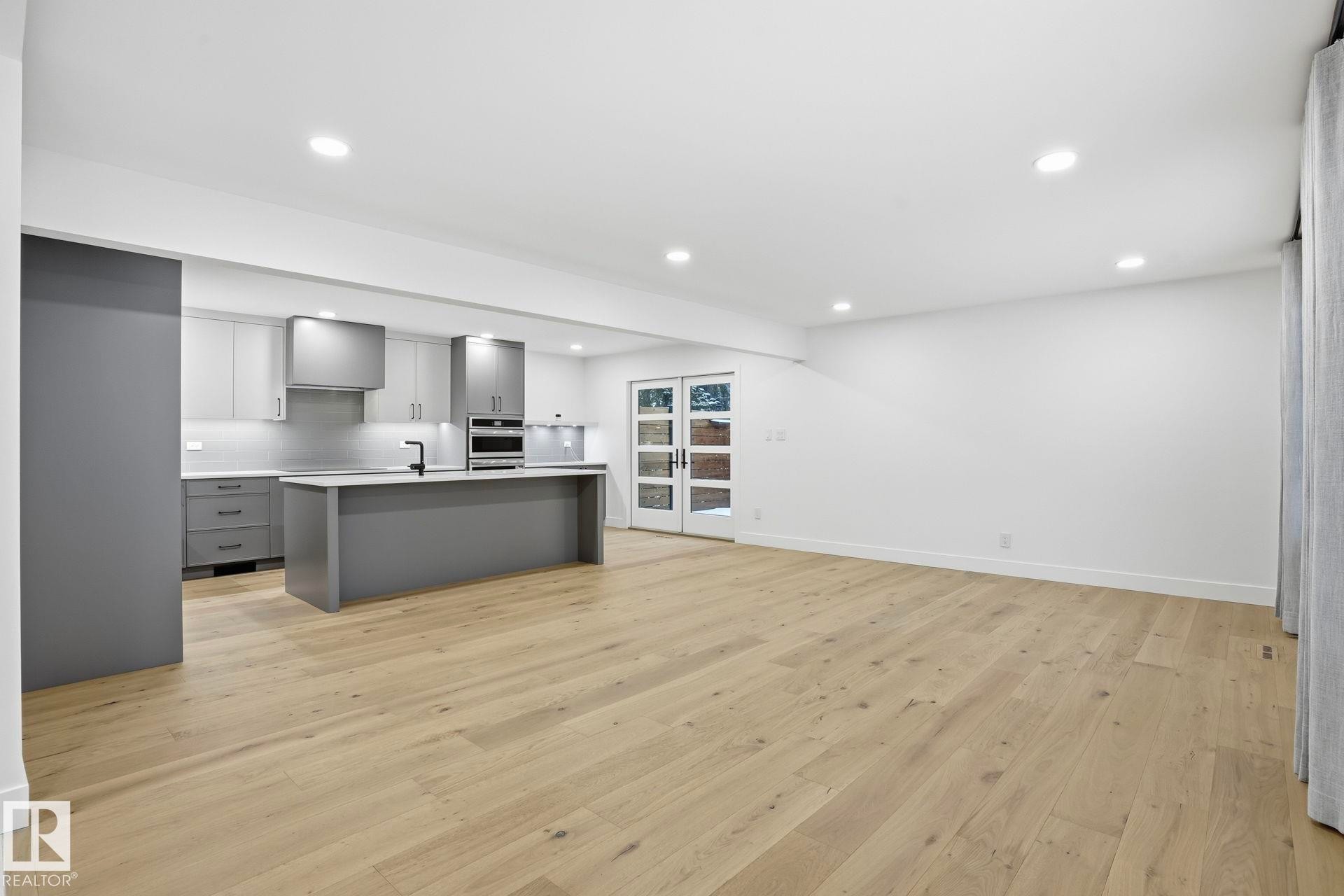 Kitchen featuring gray cabinets, light countertops, a kitchen island with sink, light wood-style floors, and recessed lighting - 14604 Mackenzie Drive, Edmonton, AB - Indoor Photo Showing Kitchen