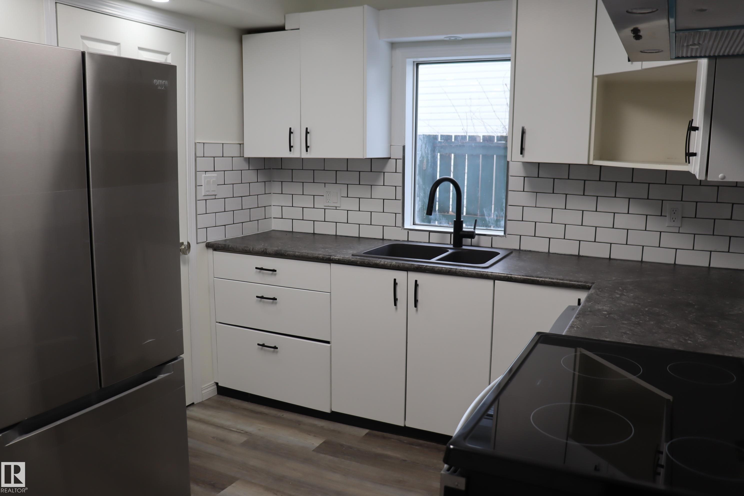 Entrance to back yard off kitchen - 4508 52 St., Wetaskiwin, AB - Indoor Photo Showing Kitchen With Double Sink