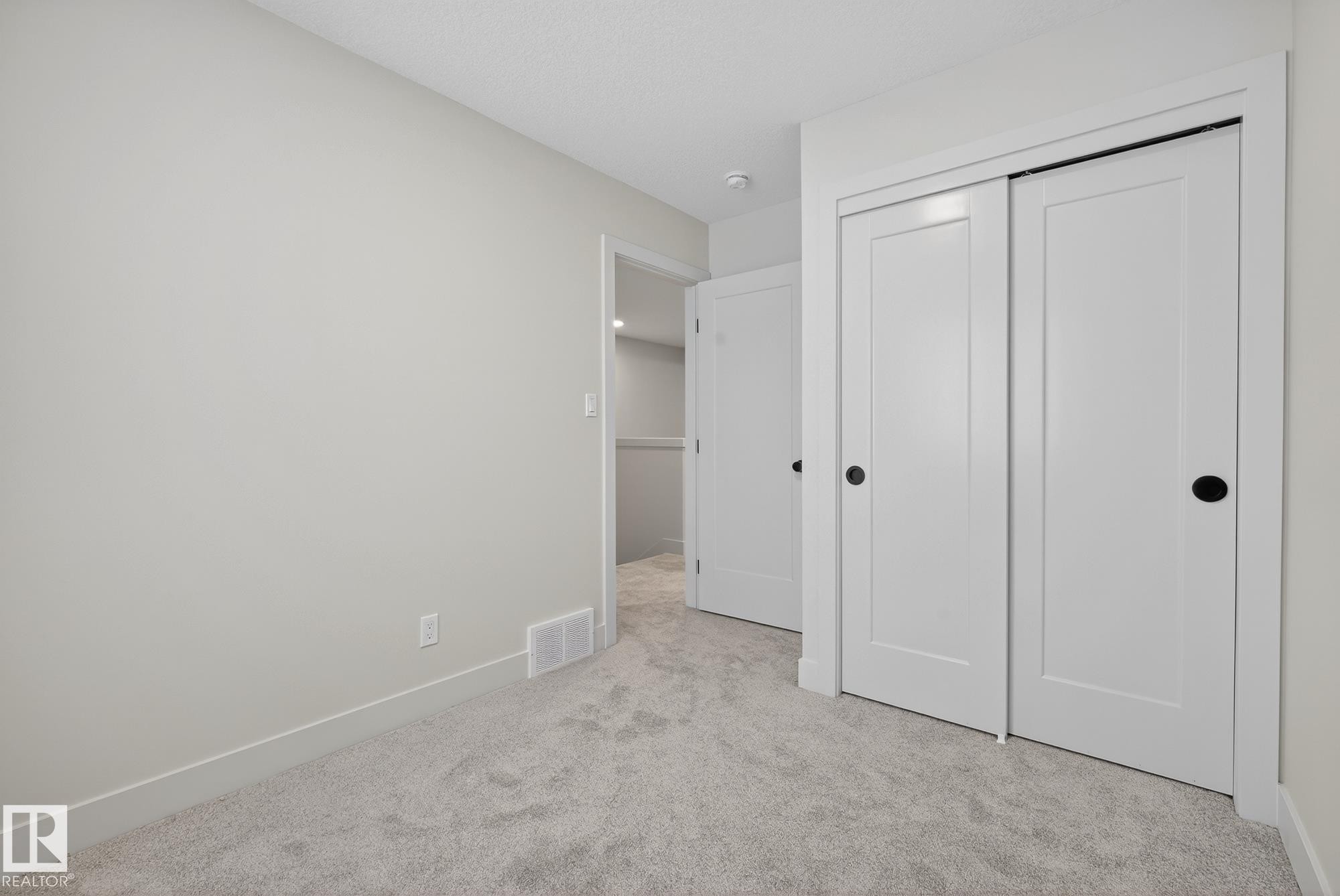Unfurnished bedroom with light colored carpet and a closet - 119 Brickyard Drive, Stony Plain, AB - Indoor Photo Showing Other Room