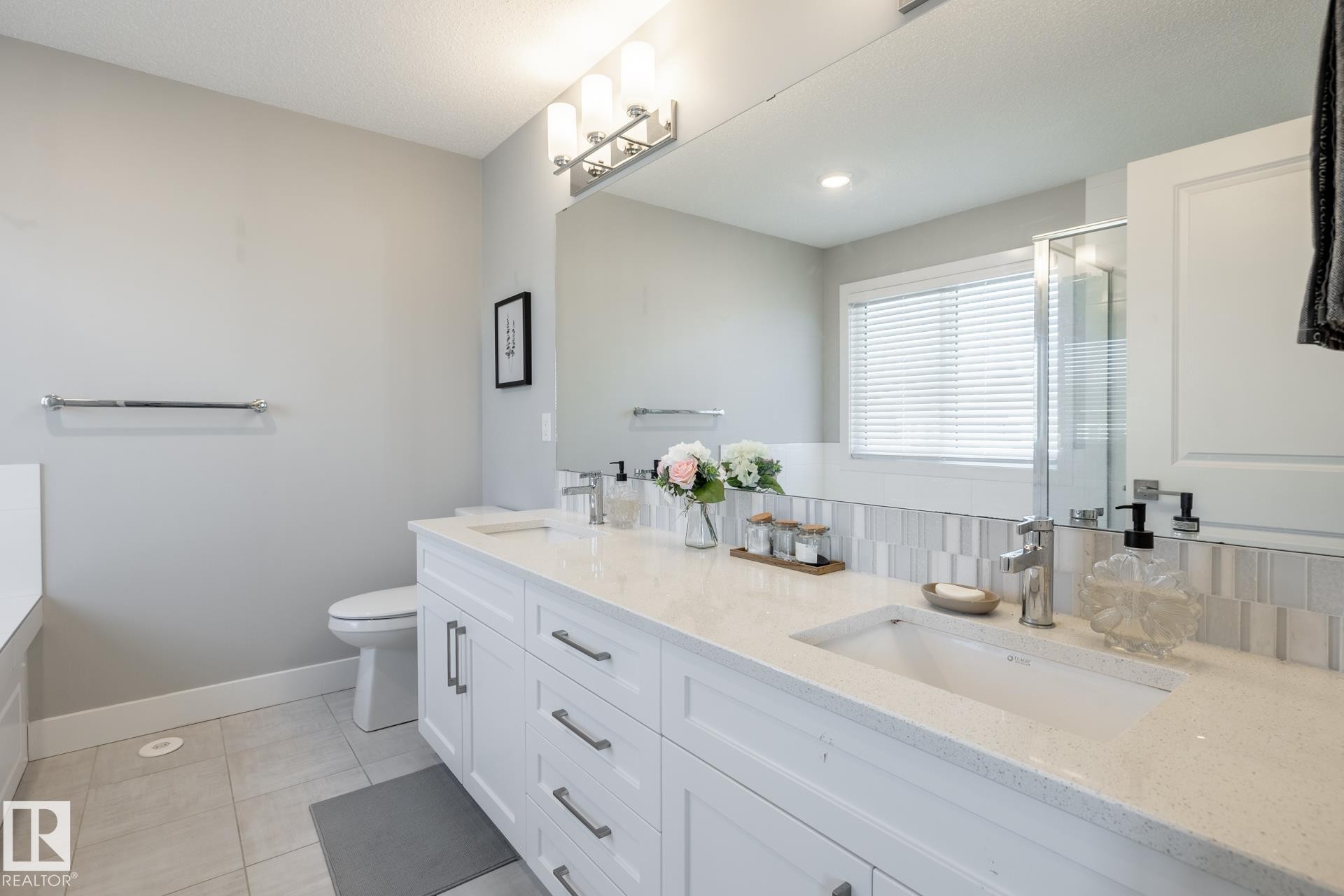Full bathroom featuring double vanity, light tile patterned floors, a stall shower, decorative backsplash, and a bath - 1440 Darby Green, Edmonton, AB - Indoor Photo Showing Bathroom