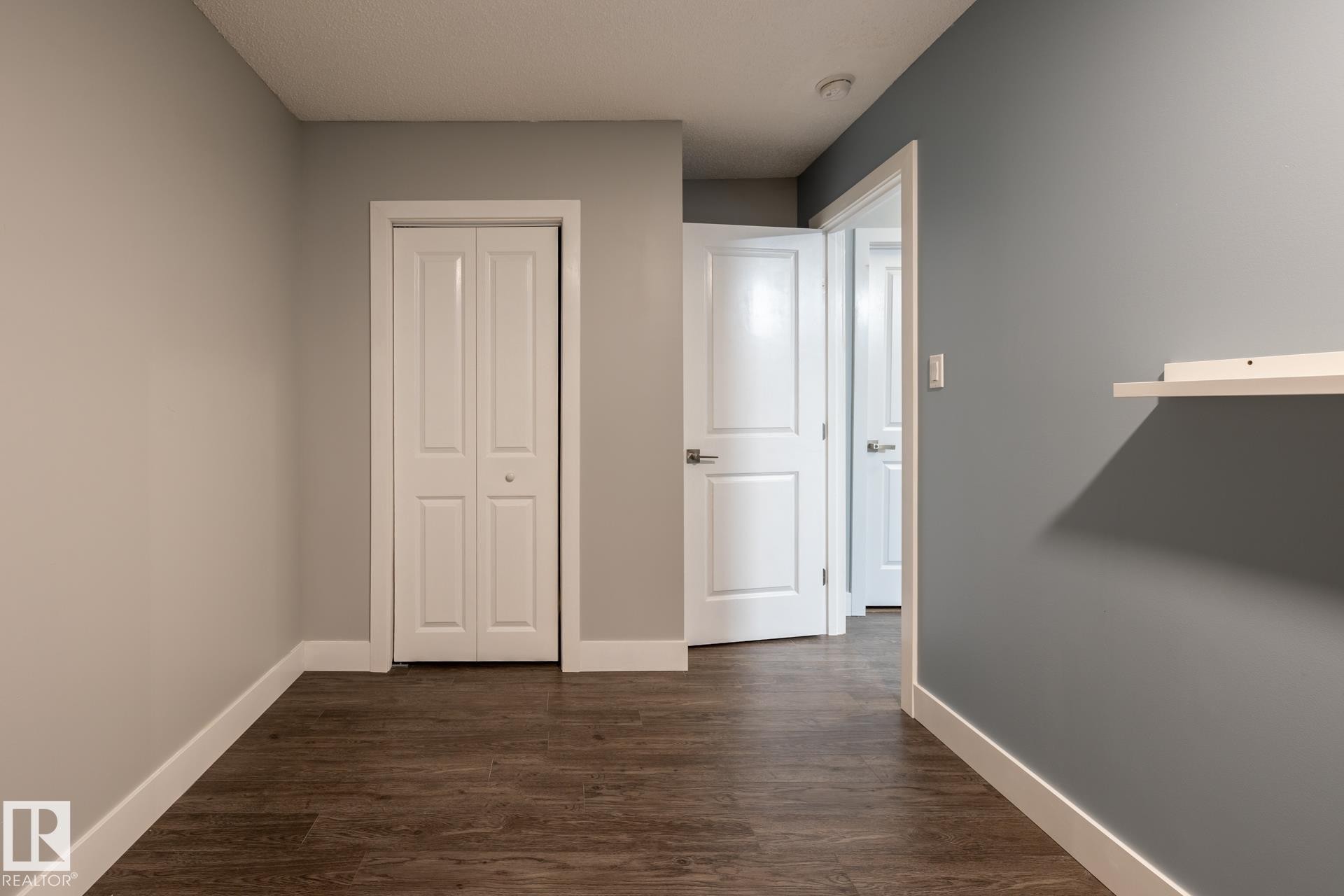 Bedroom with dark wood-style flooring and a closet - 1440 Darby Green, Edmonton, AB - Indoor Photo Showing Other Room