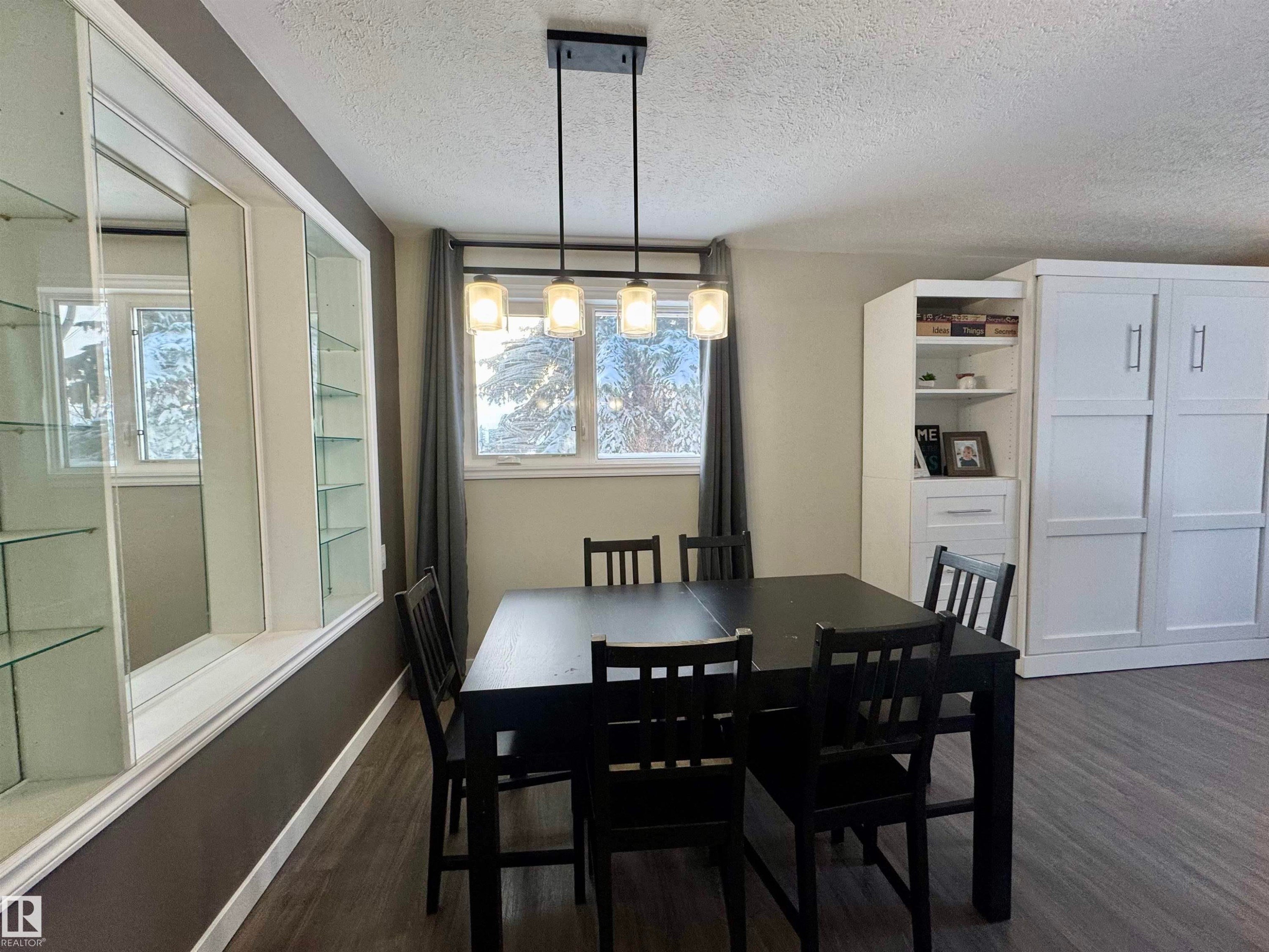 Dining area with dark wood-style floors, a textured ceiling, and healthy amount of natural light - 5140 52 Avenue, Ryley, AB - Indoor Photo Showing Dining Room
