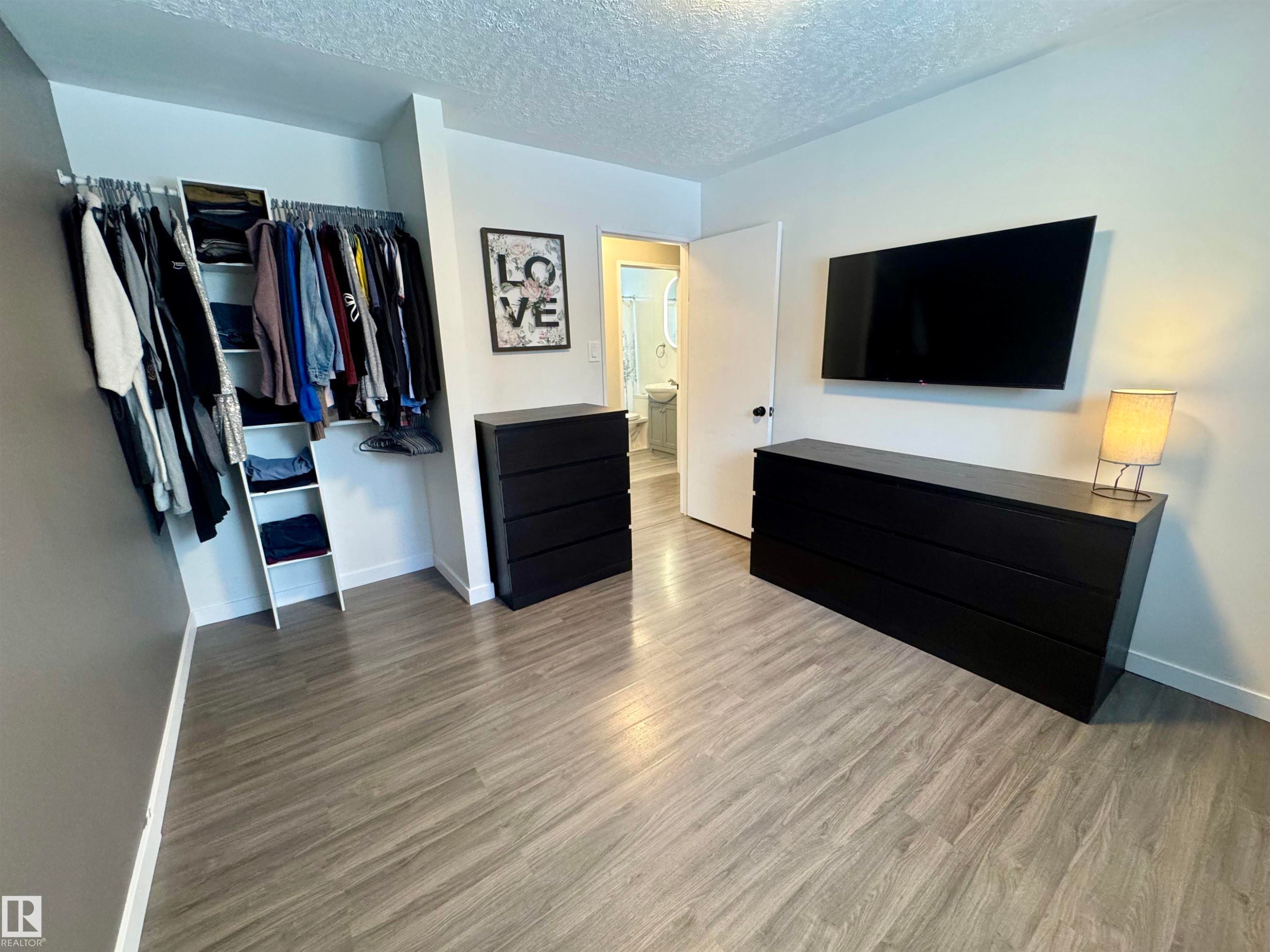Bedroom with a closet, a textured ceiling, and wood finished floors - 5140 52 Avenue, Ryley, AB - Indoor