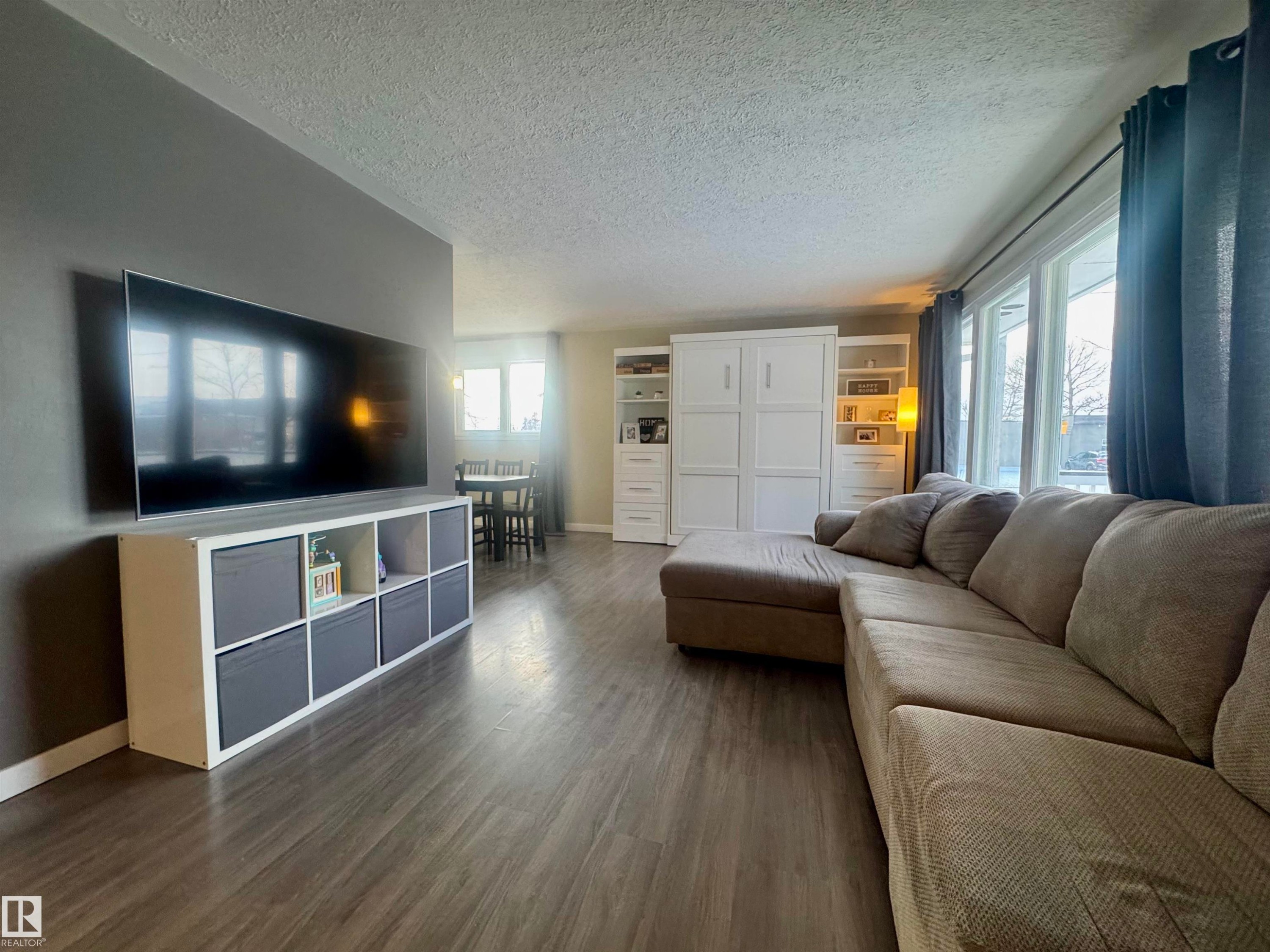 Living area with a textured ceiling and dark wood-style floors - 5140 52 Avenue, Ryley, AB - Indoor Photo Showing Living Room