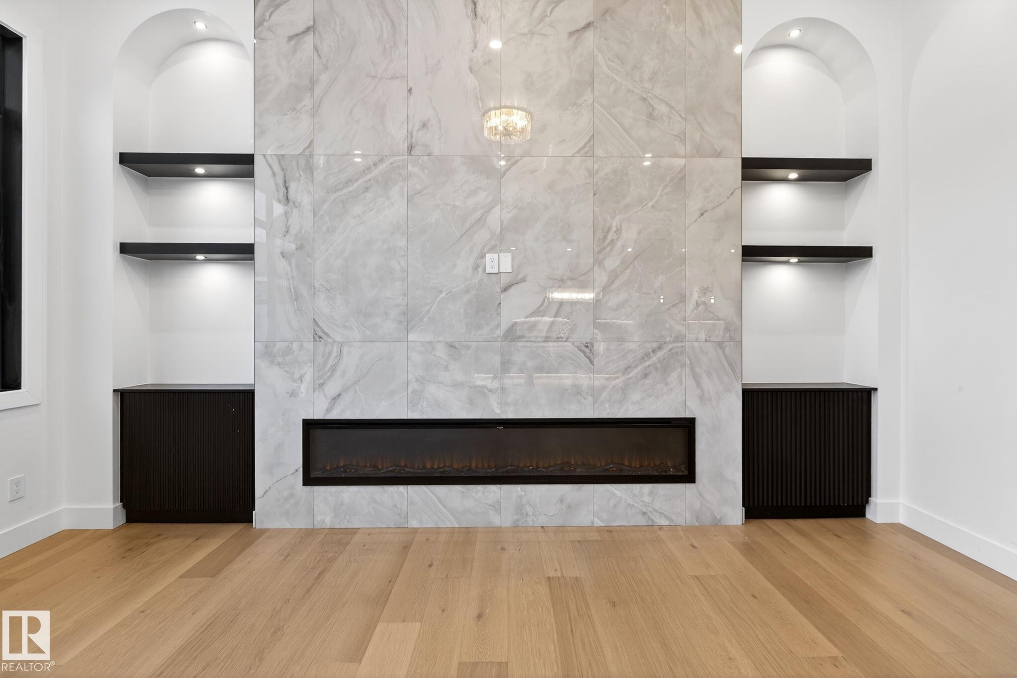 Detailed view of a high end fireplace and wood finished floors - 1926 Ainslie Link, Edmonton, AB - Indoor With Fireplace