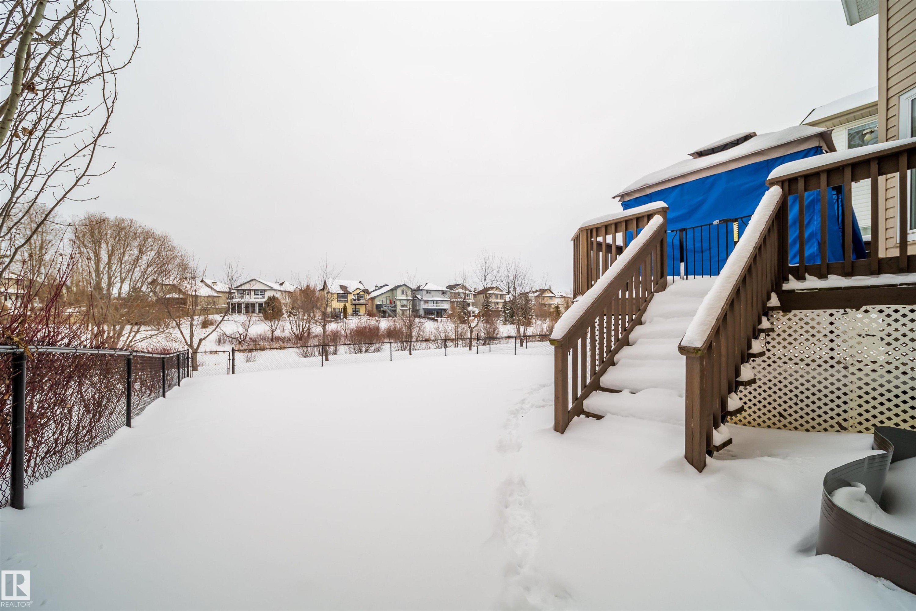 Snowy yard with stairway, a wooden deck, and a residential view - 8518 6 Av, Edmonton, AB - Outdoor