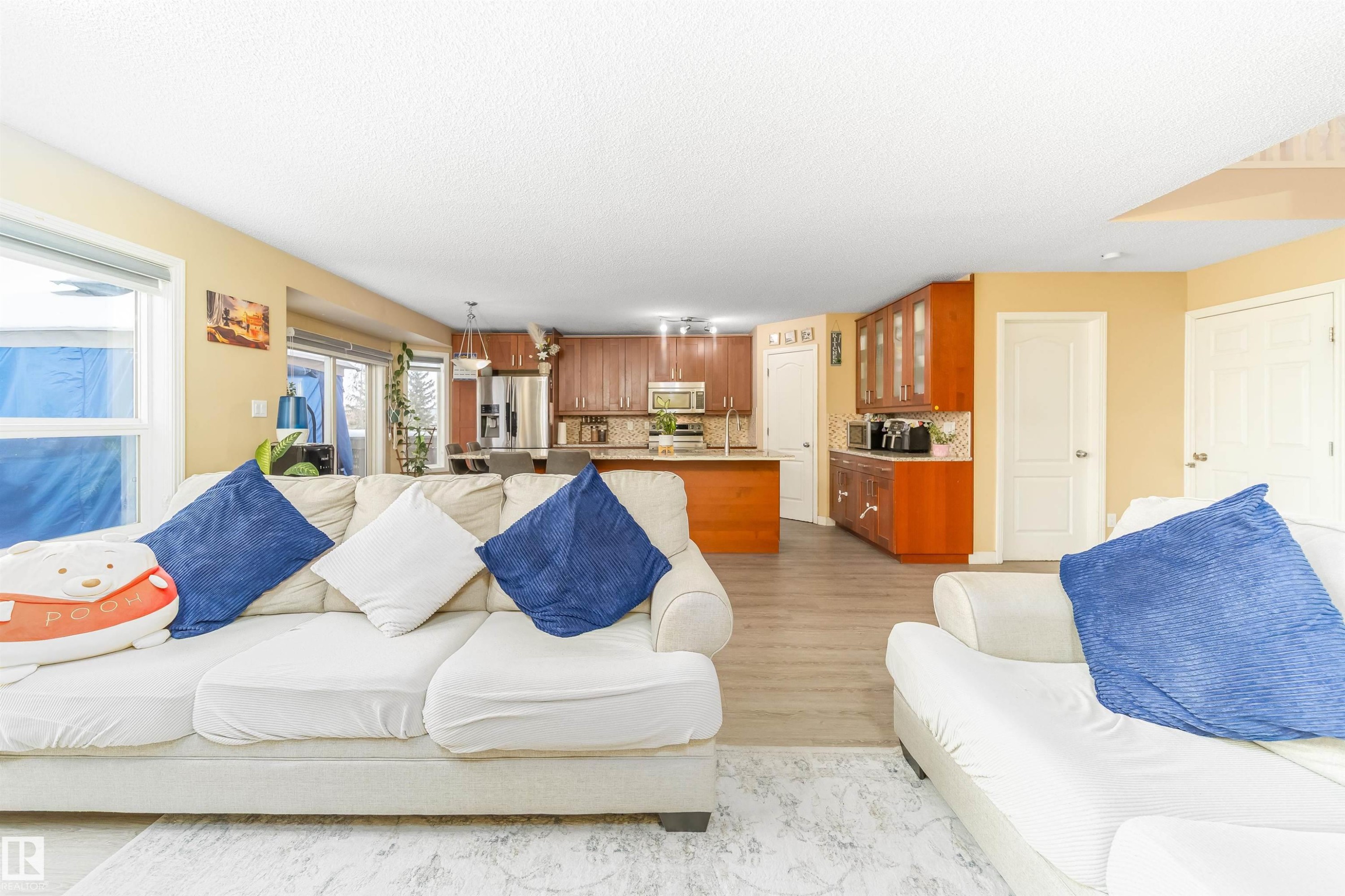 Living room featuring light wood-style flooring and a textured ceiling - 8518 6 Av, Edmonton, AB - Indoor Photo Showing Living Room