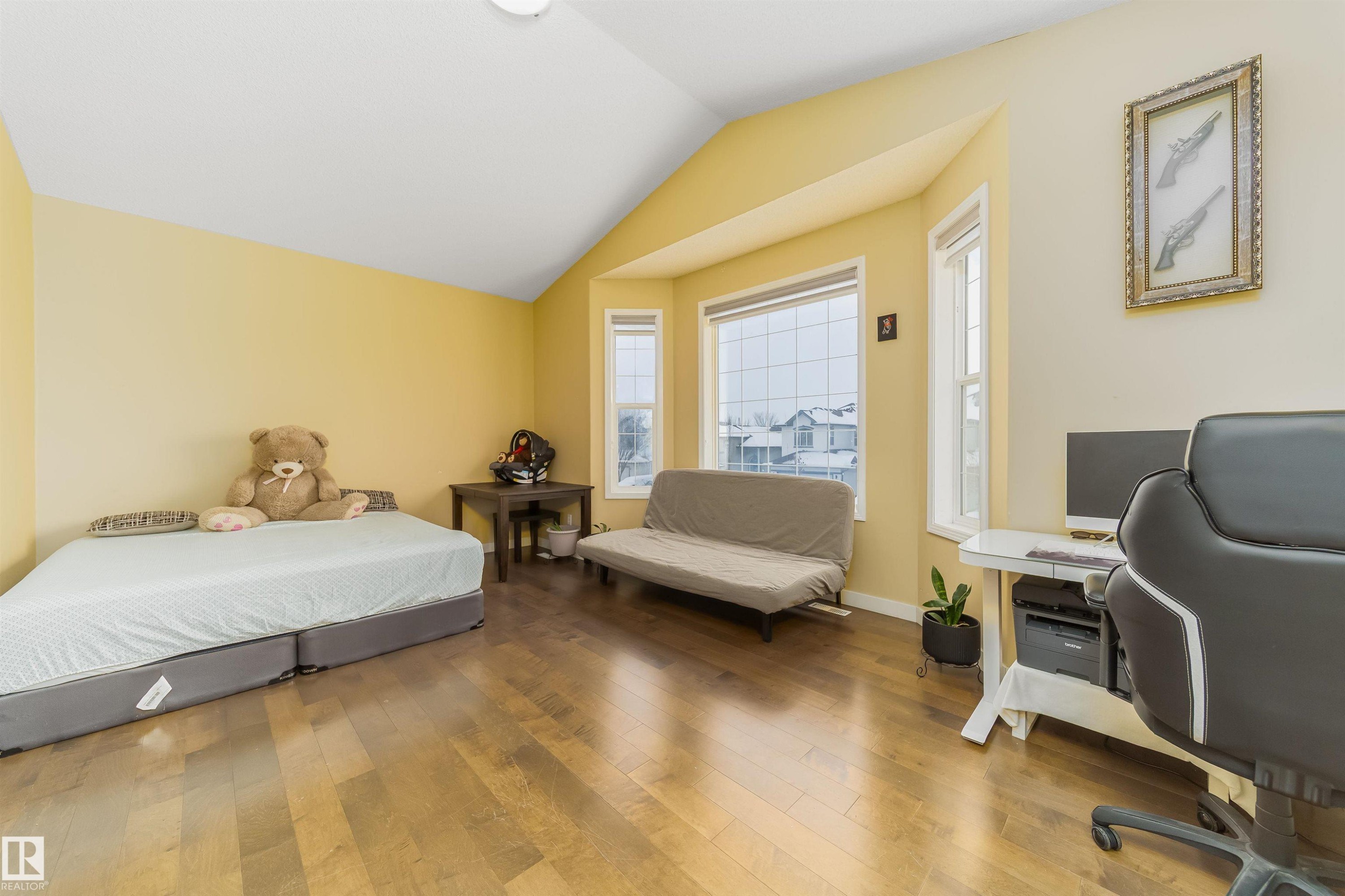 Bedroom featuring wood-type flooring, vaulted ceiling, and a desk - 8518 6 Av, Edmonton, AB - Indoor Photo Showing Bedroom