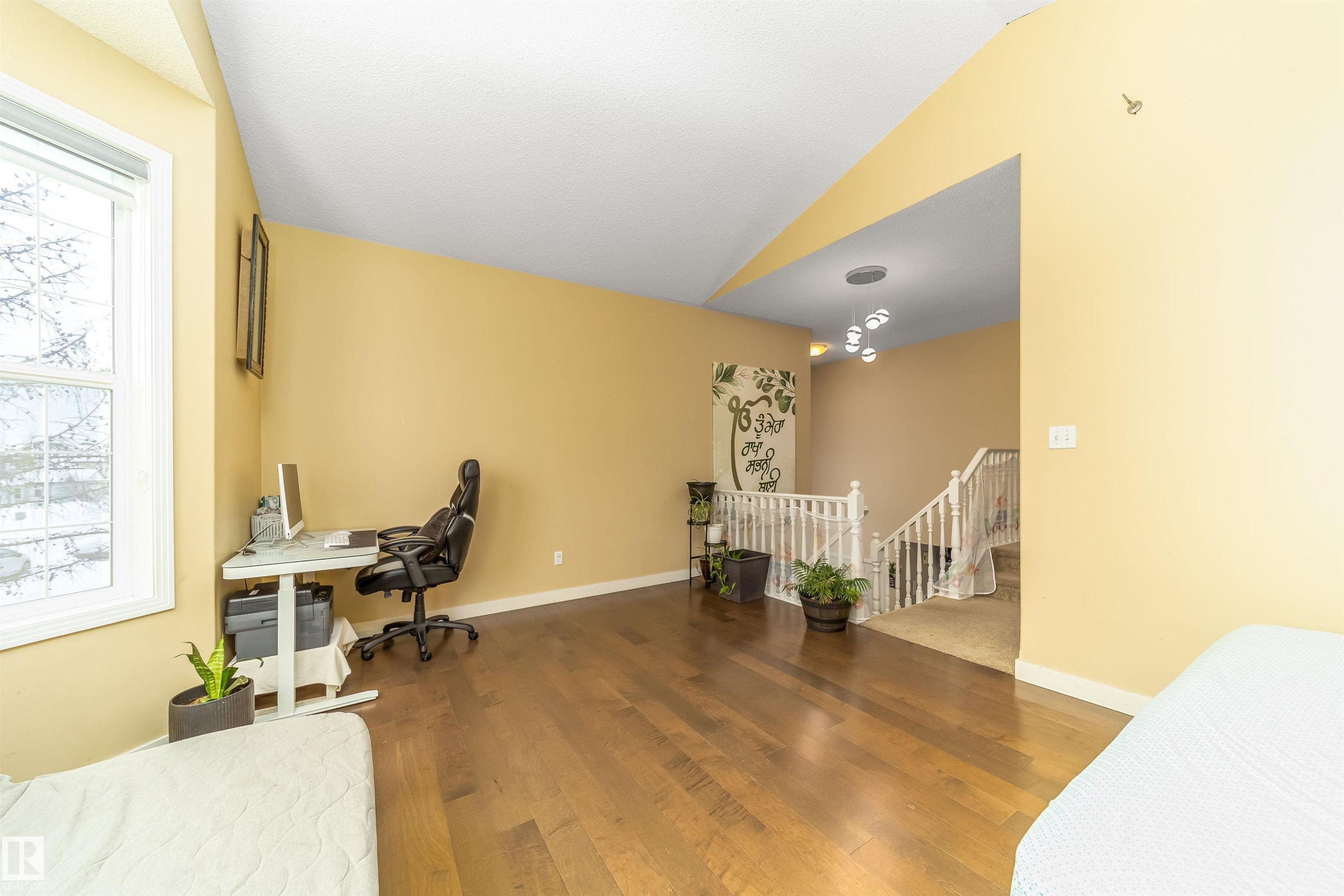 Home office featuring lofted ceiling and wood finished floors - 8518 6 Av, Edmonton, AB - Indoor