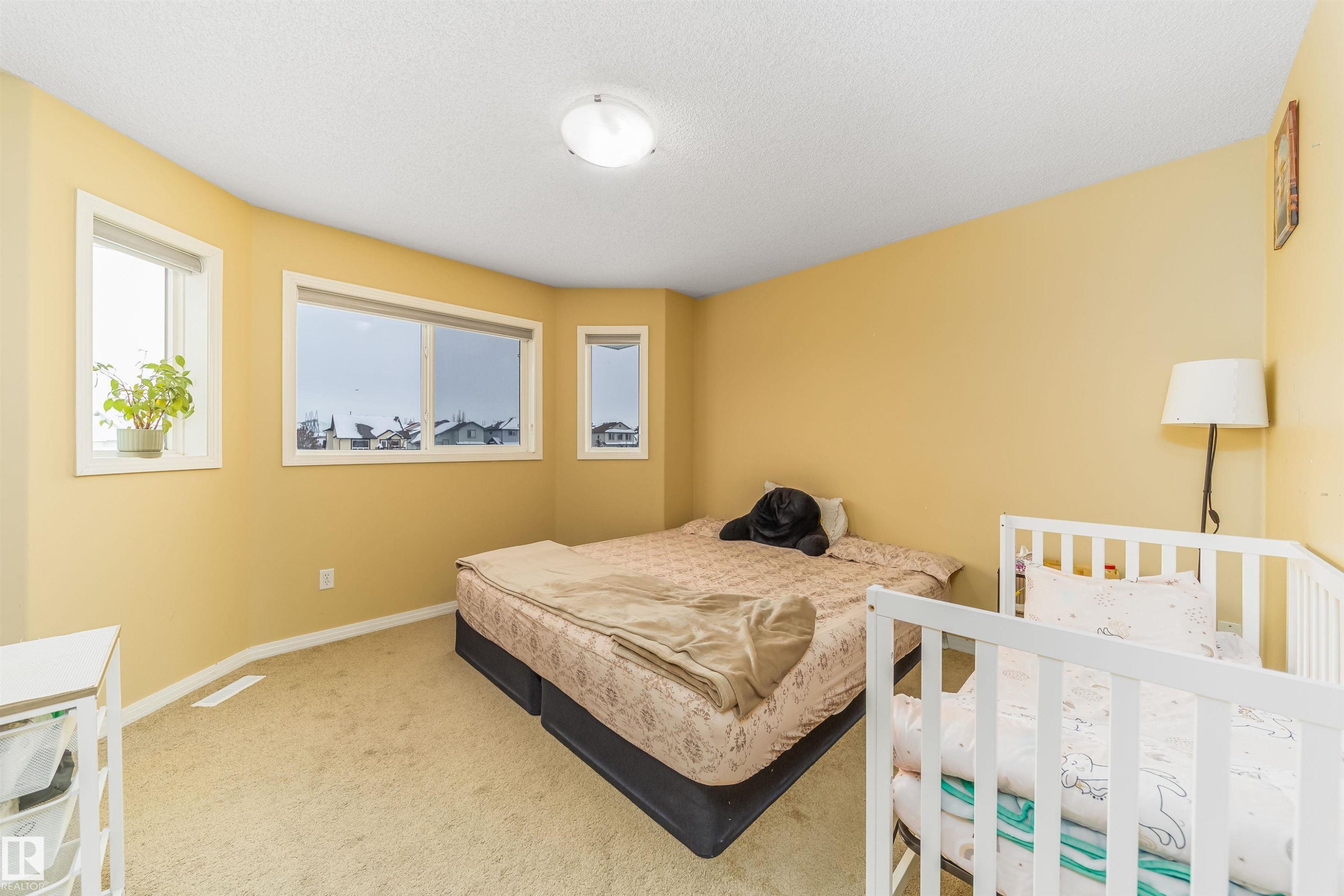 Bedroom with carpet floors and a textured ceiling - 8518 6 Av, Edmonton, AB - Indoor Photo Showing Bedroom