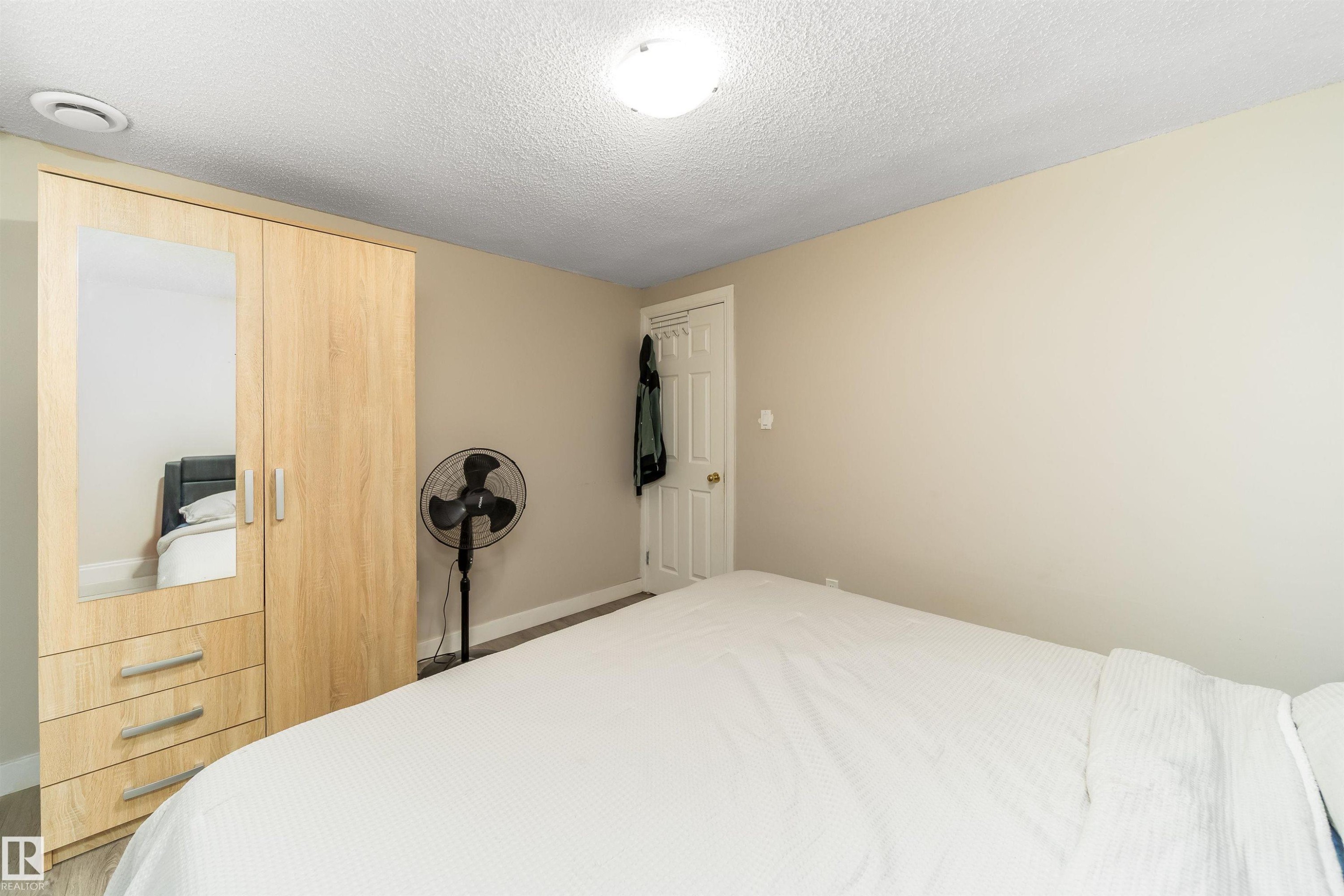 Bedroom featuring a textured ceiling and a closet - 8518 6 Av, Edmonton, AB - Indoor Photo Showing Bedroom